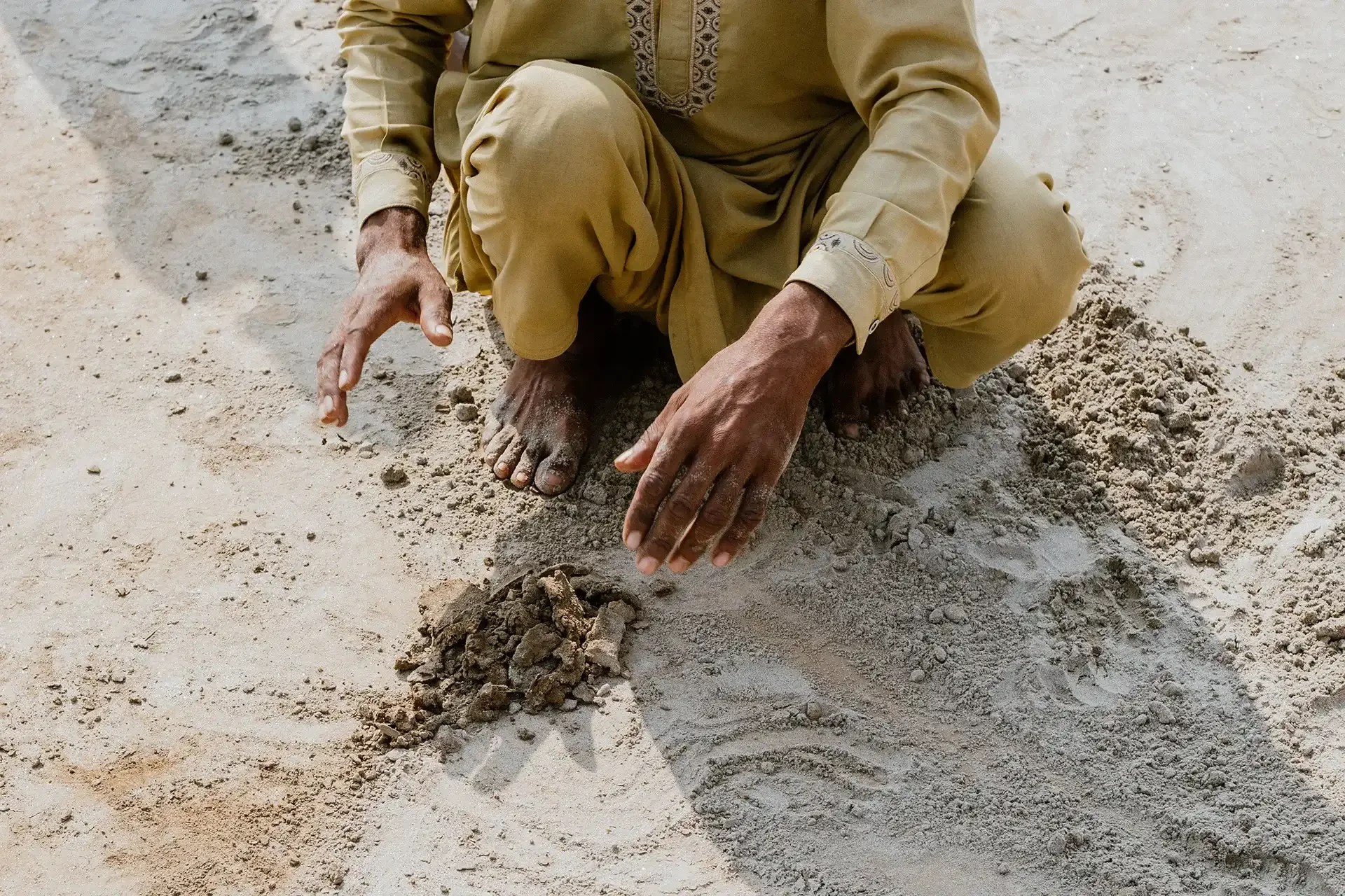 Man mixes dirt clay to make bricks