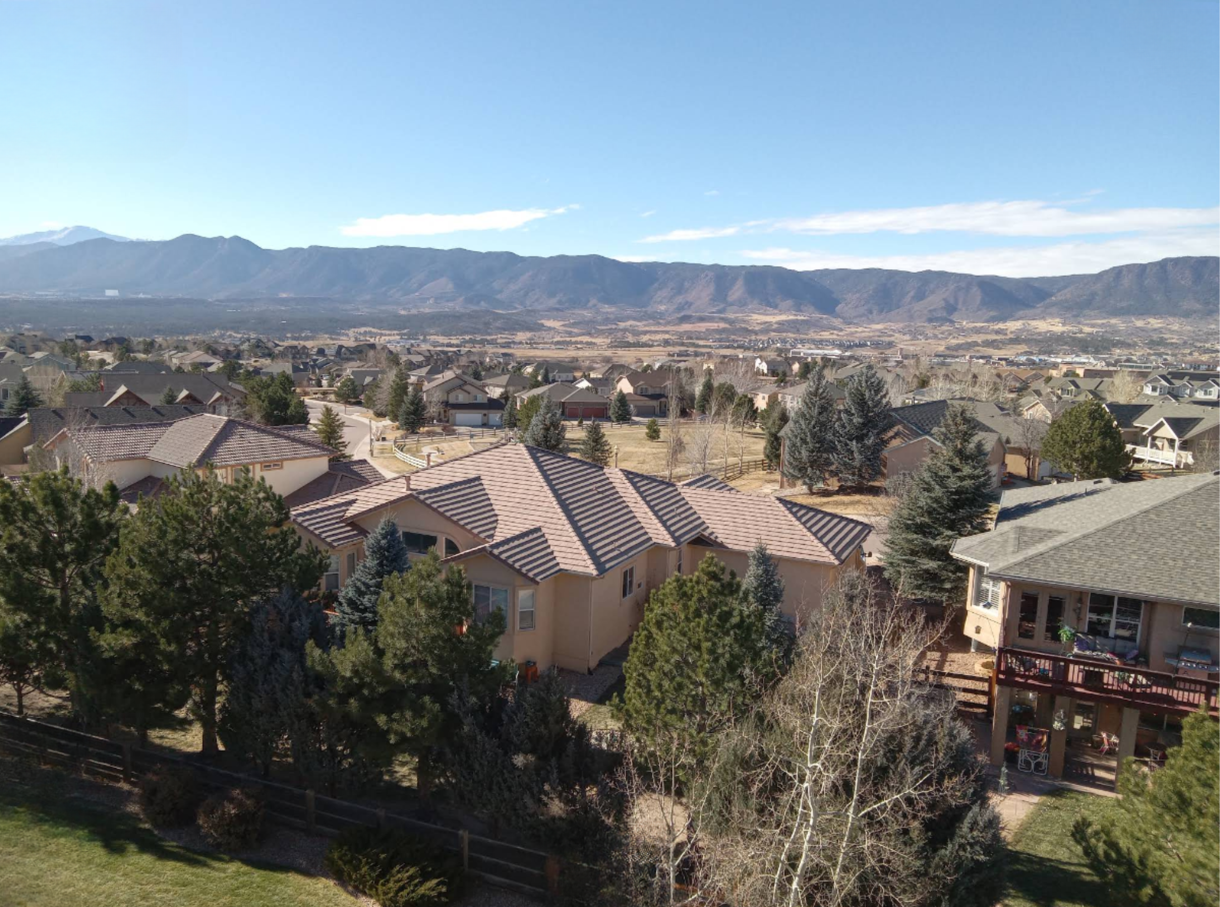 aerial image of a suburban monument colorado neighborhood with mountains in the background on a clear sunny day