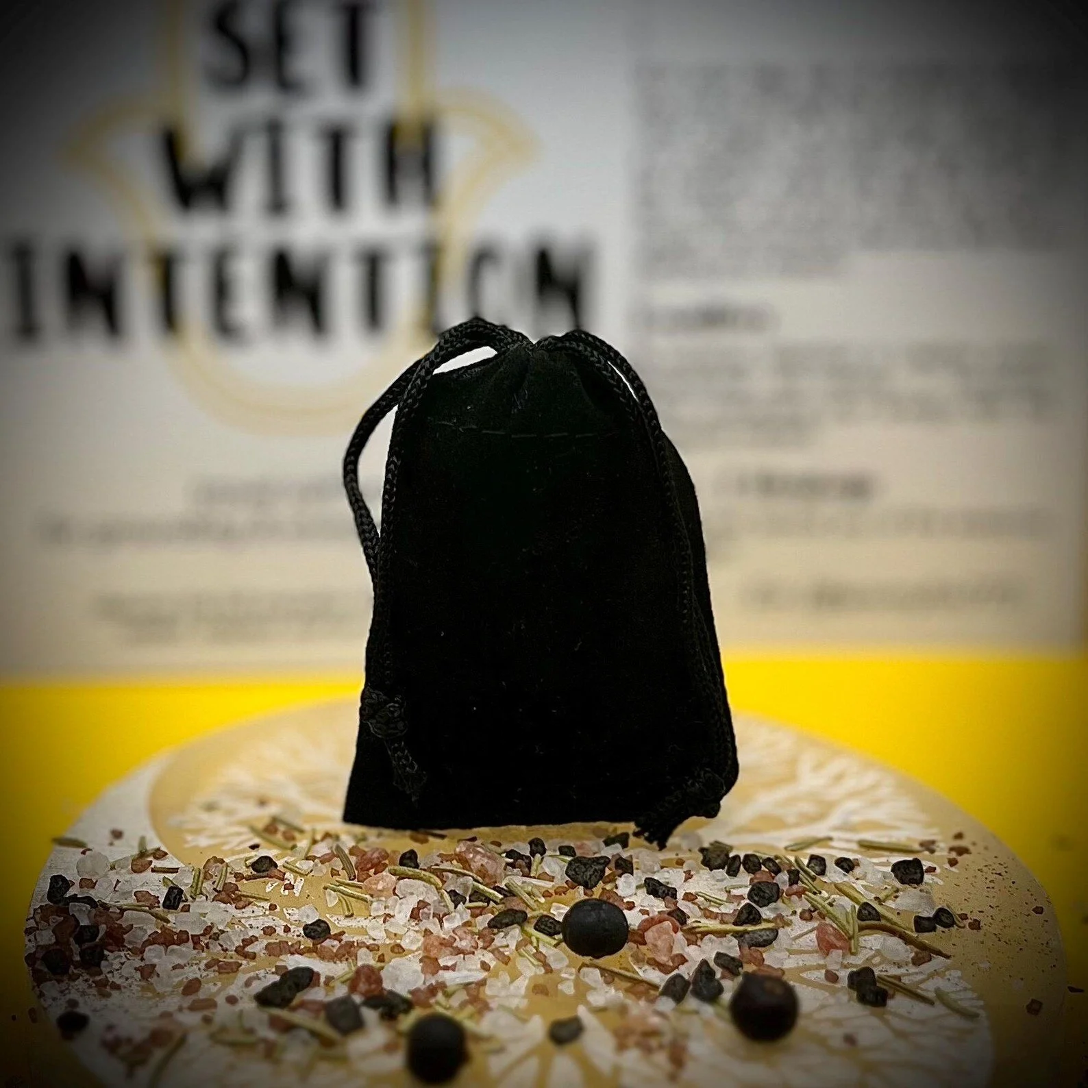 intention-setting ritual kit in a black velvet pouch, styled with crystals and herbs in front of a blurred “set with intention” sign.