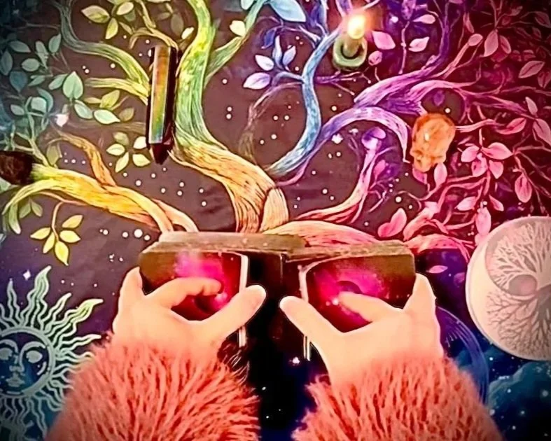 hands in fluffy orange sleeves mid-shuffle, holding tarot cards against a glowing, psychedelic forest scene with vibrant trees, a moon, and celestial symbols in the background