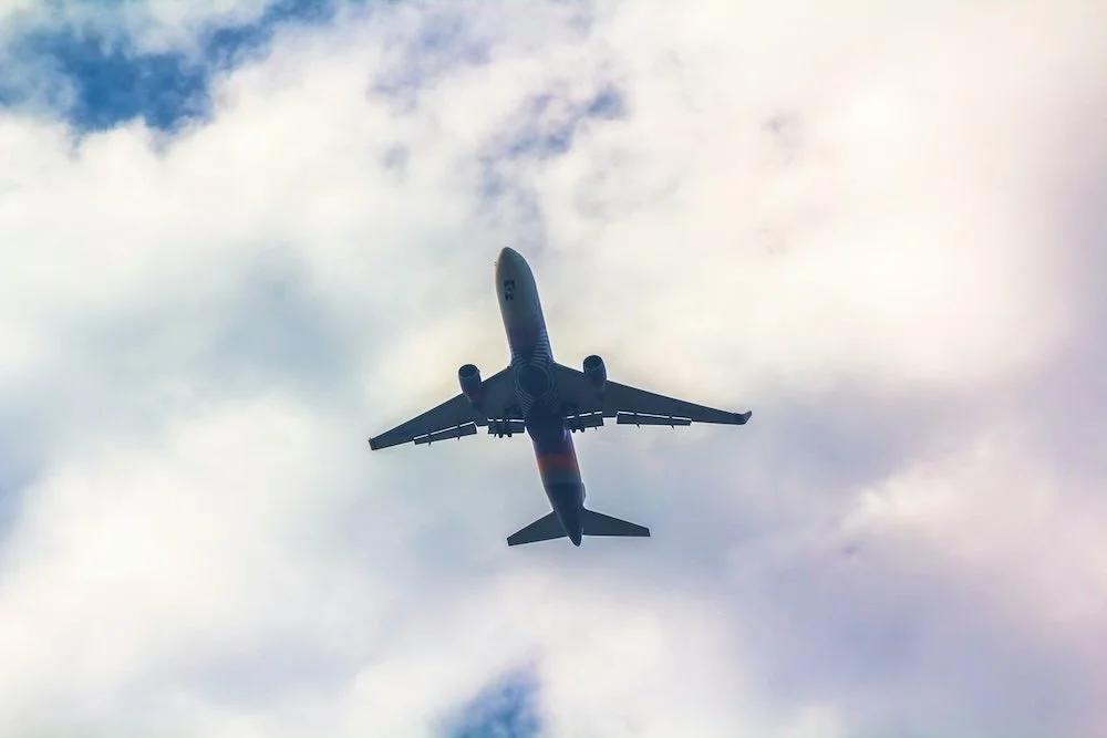 Commercial airplane flying high in the sky with clouds.
