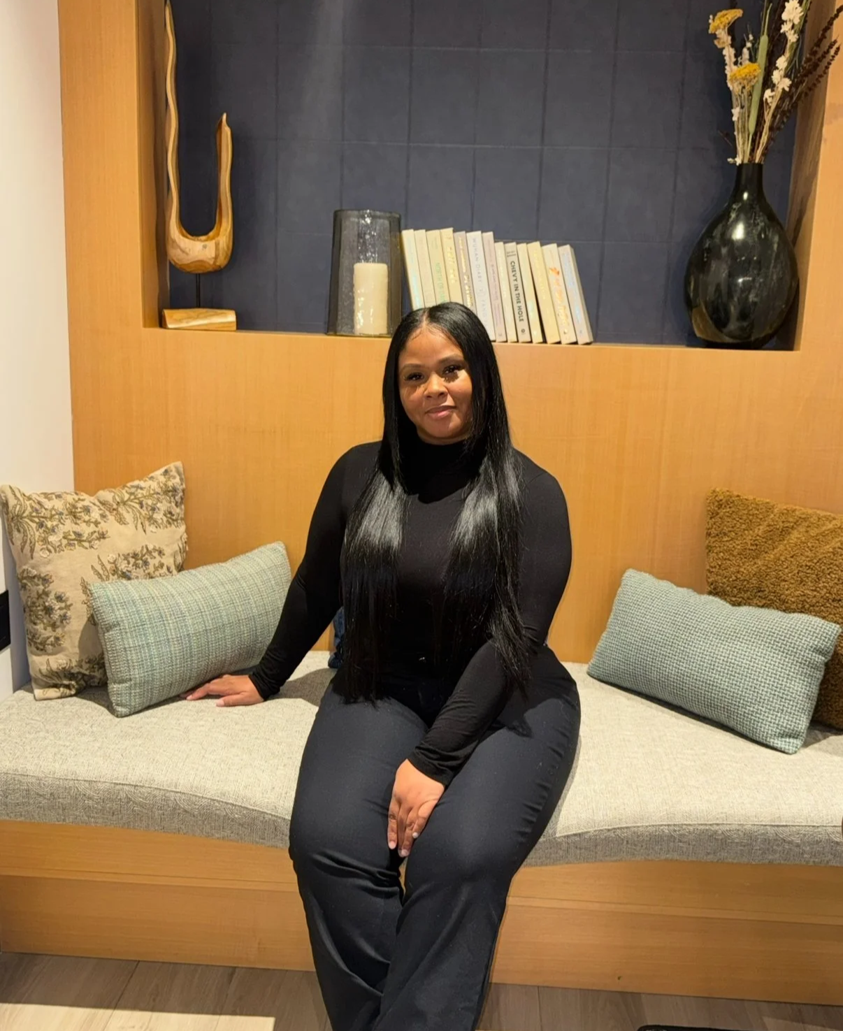 3D cartoon character of a smiling boy with black, wavy hair, wearing a purple and yellow striped shirt, set against a pink background.