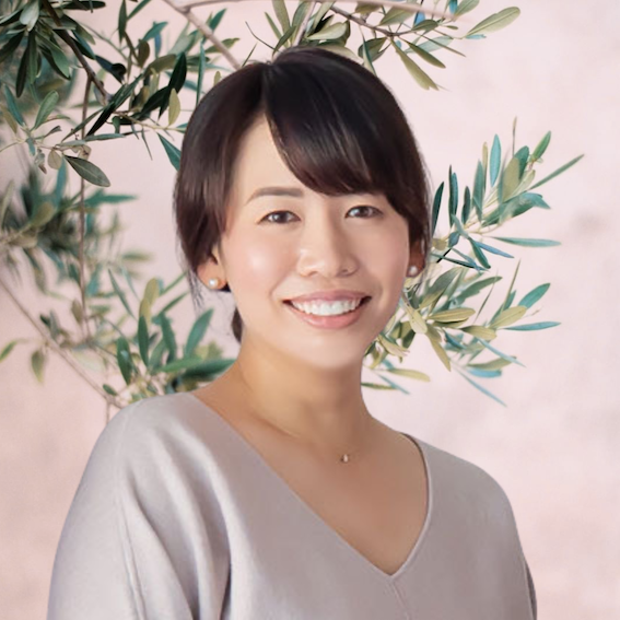 Akiko Kay smiling against a pink background with a tree painted on it.