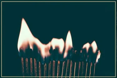 Close-up of matches with one match lit and burning with a flame
