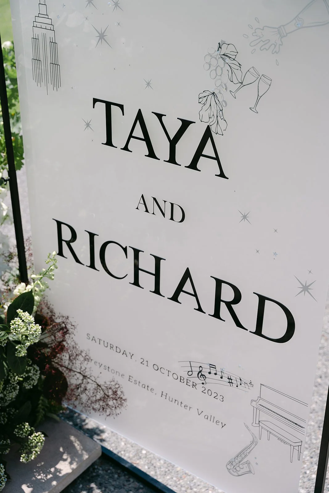 Wedding event sign for Taya and Richard, scheduled on Saturday, October 21, 2023, at Keystone Estate, Hunter Valley, featuring musical notes, a grand piano, and a saxophone illustration.