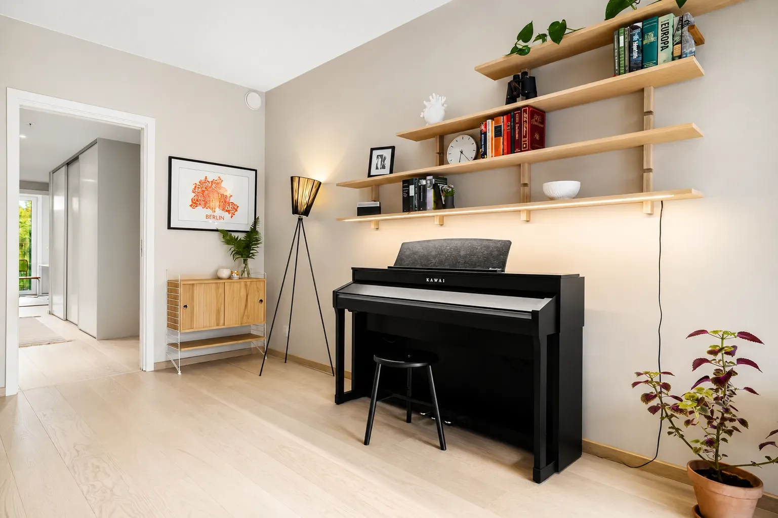 Clean minimalist living space with hardwood floors, modern shelving, and organized home interior.