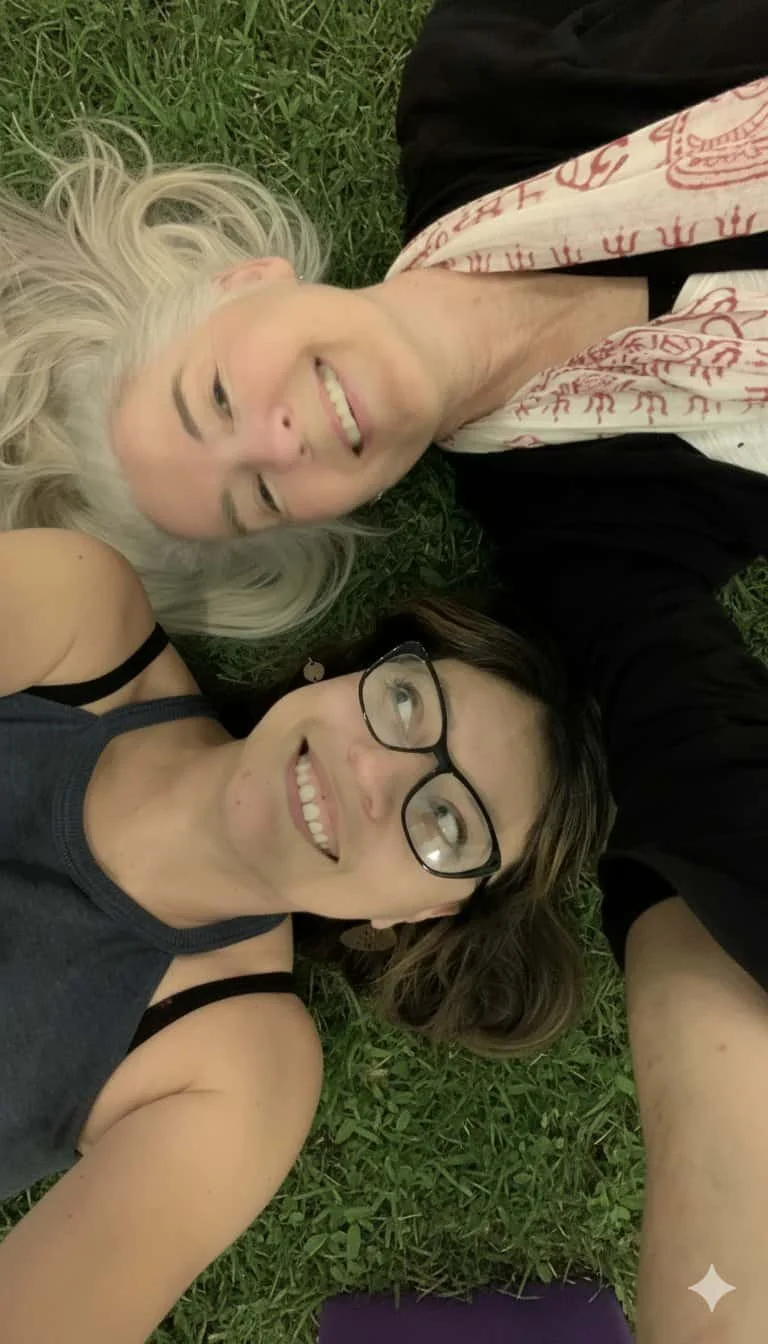 Melanie and Veronica on green grass, smiling and looking up at the camera.