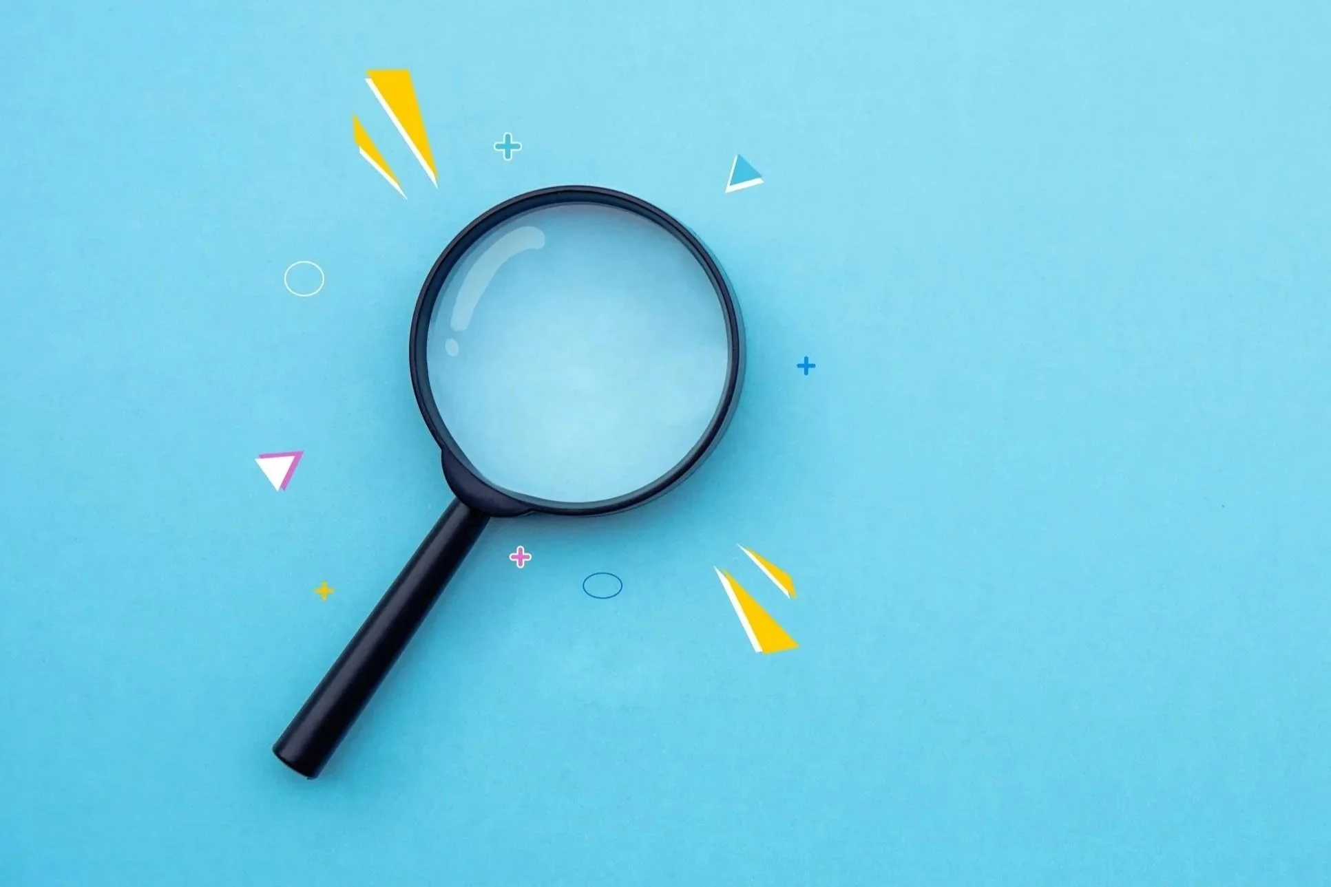 Black magnifying glass on a light blue background with colorful abstract geometric shapes surrounding it.