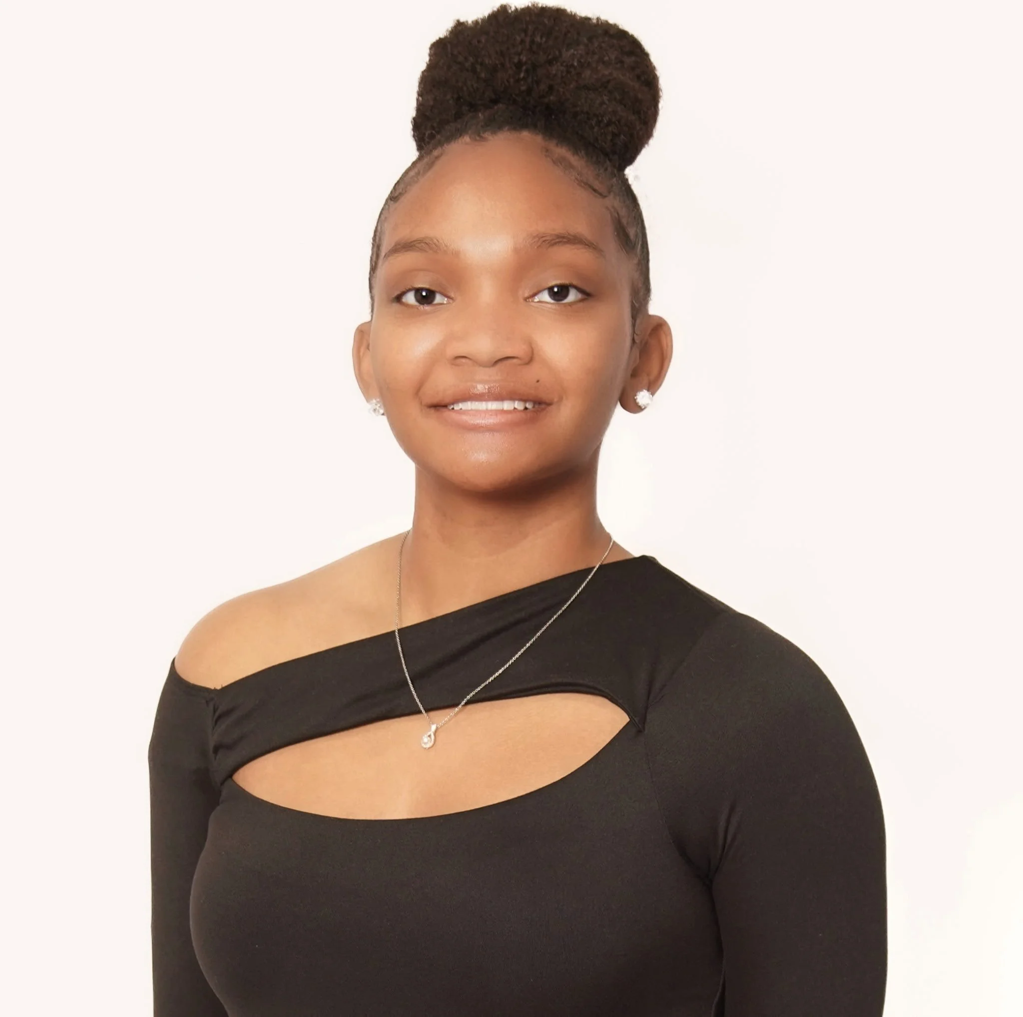 Young Lady wearing with a bun, wearing black and smiling.