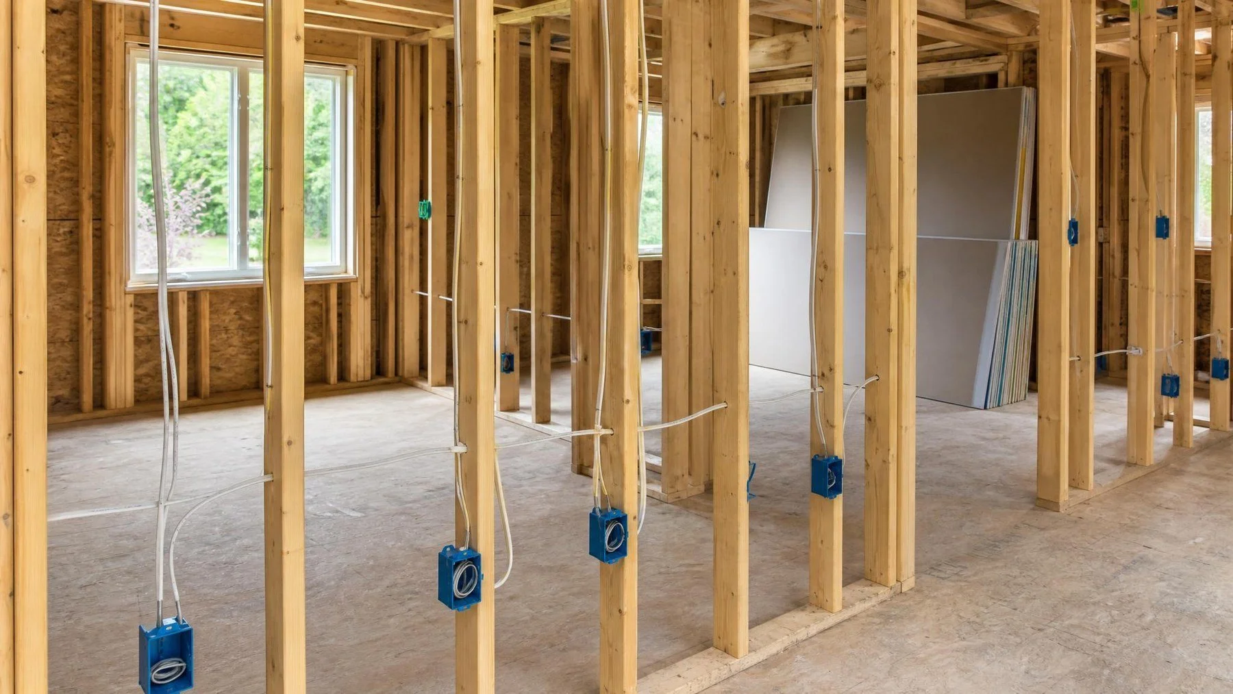 Organized electrical cables and device boxes in open wall framing before an Ontario rough in inspection