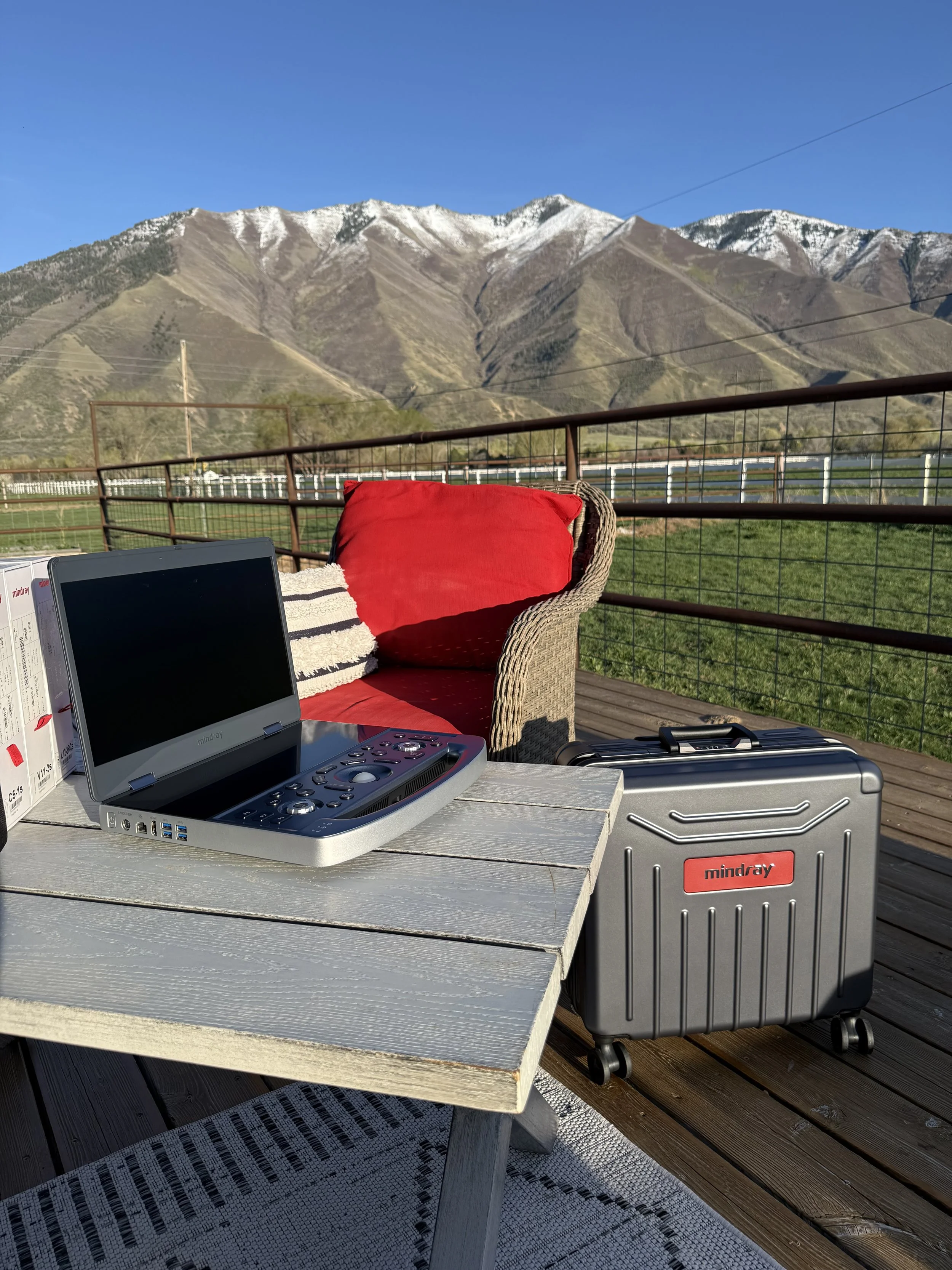 Portable Mindray MX7 ultrasound system and carrying case set up outdoors with Utah mountains in the background.