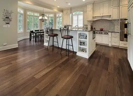 Open kitchen and dining area with white cabinetry, island, and hardwood floors.