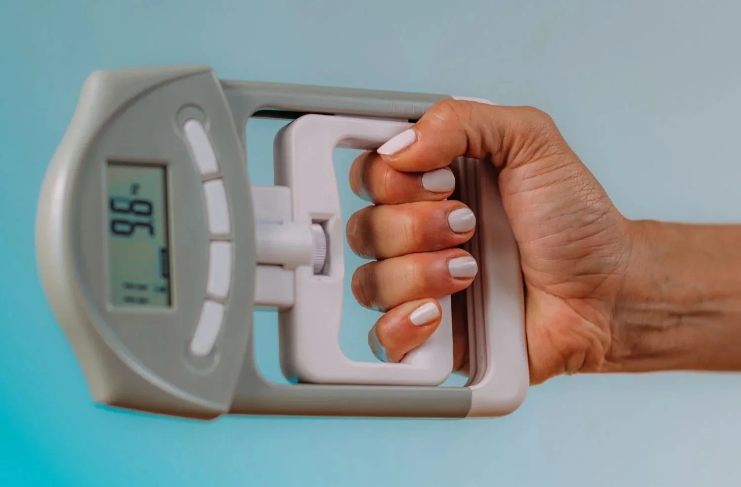 Person holding a glucometer displaying a blood sugar level of 95, with a test strip inserted for blood glucose testing.