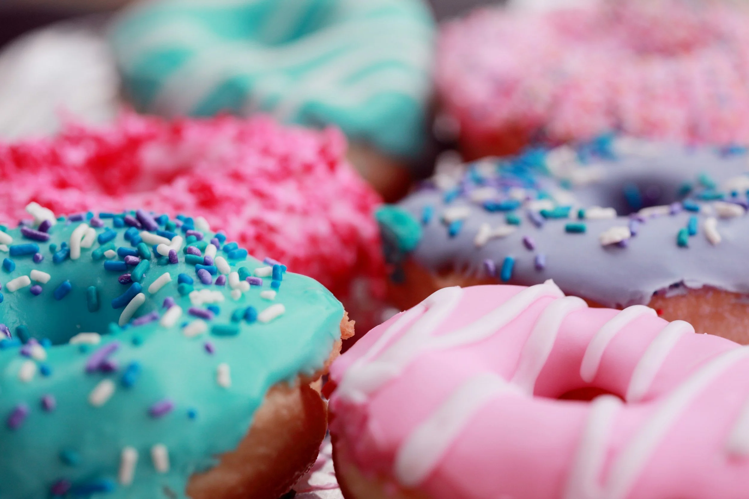 Colorful donuts with pastel icing and sprinkles.