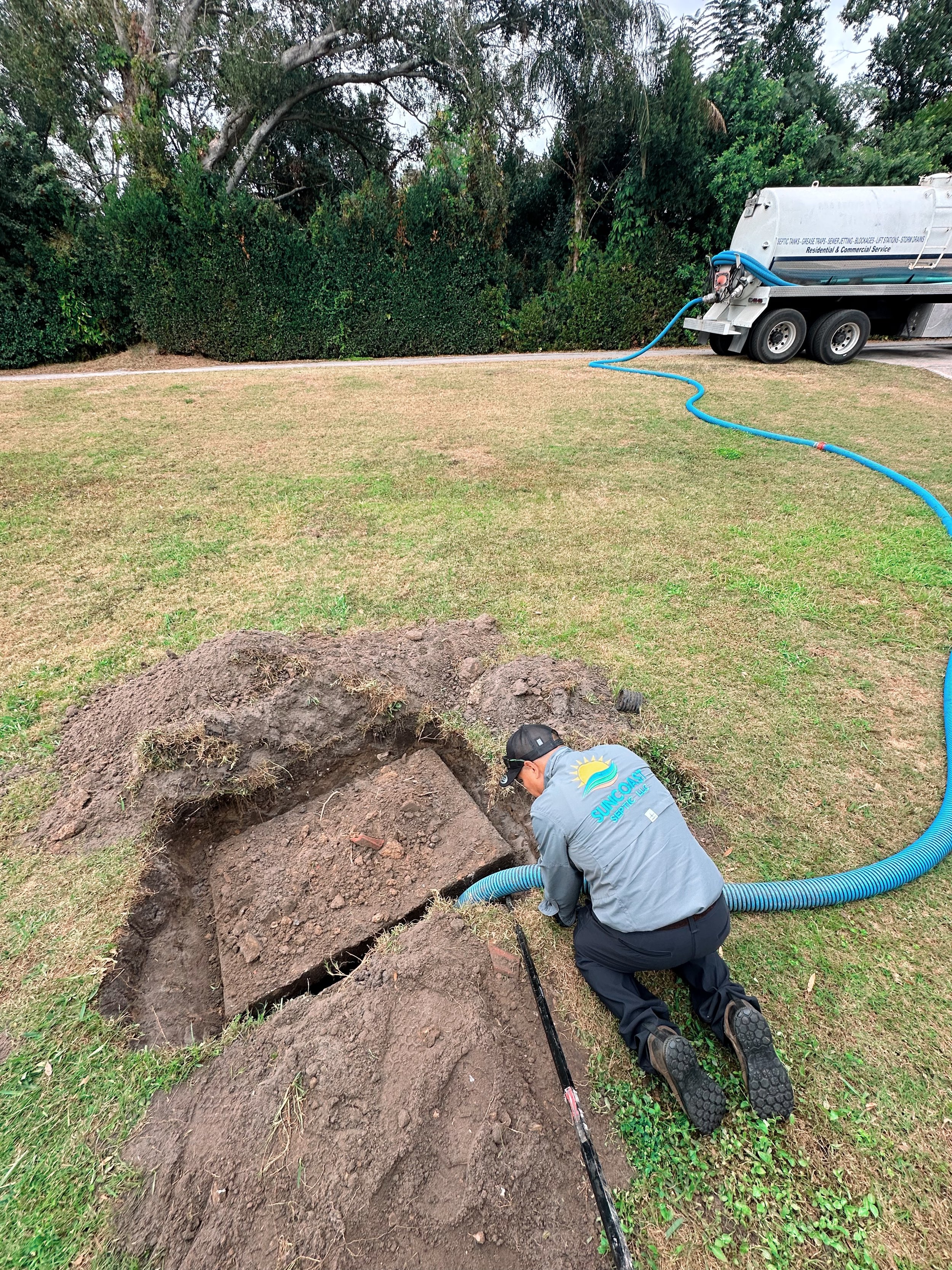 A Suncoast Septic worker pumping/cleaning a septic tank during an inspection