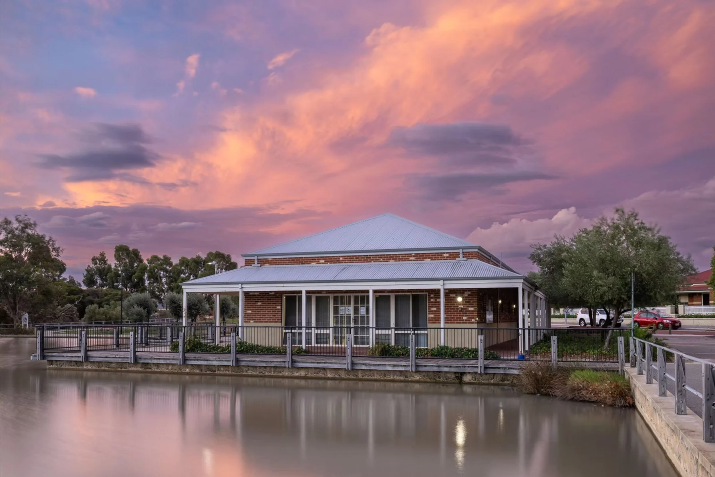 ID: The Grapevine under a dusky sky. A lake sits in the foreground.