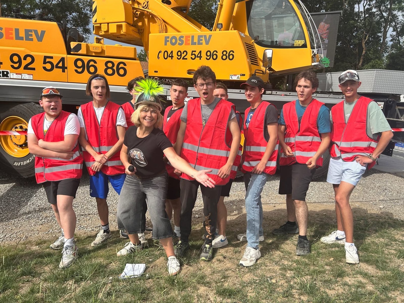 Une équipe en gilets rouges devant la grue, sur le site des épreuves à Gap
