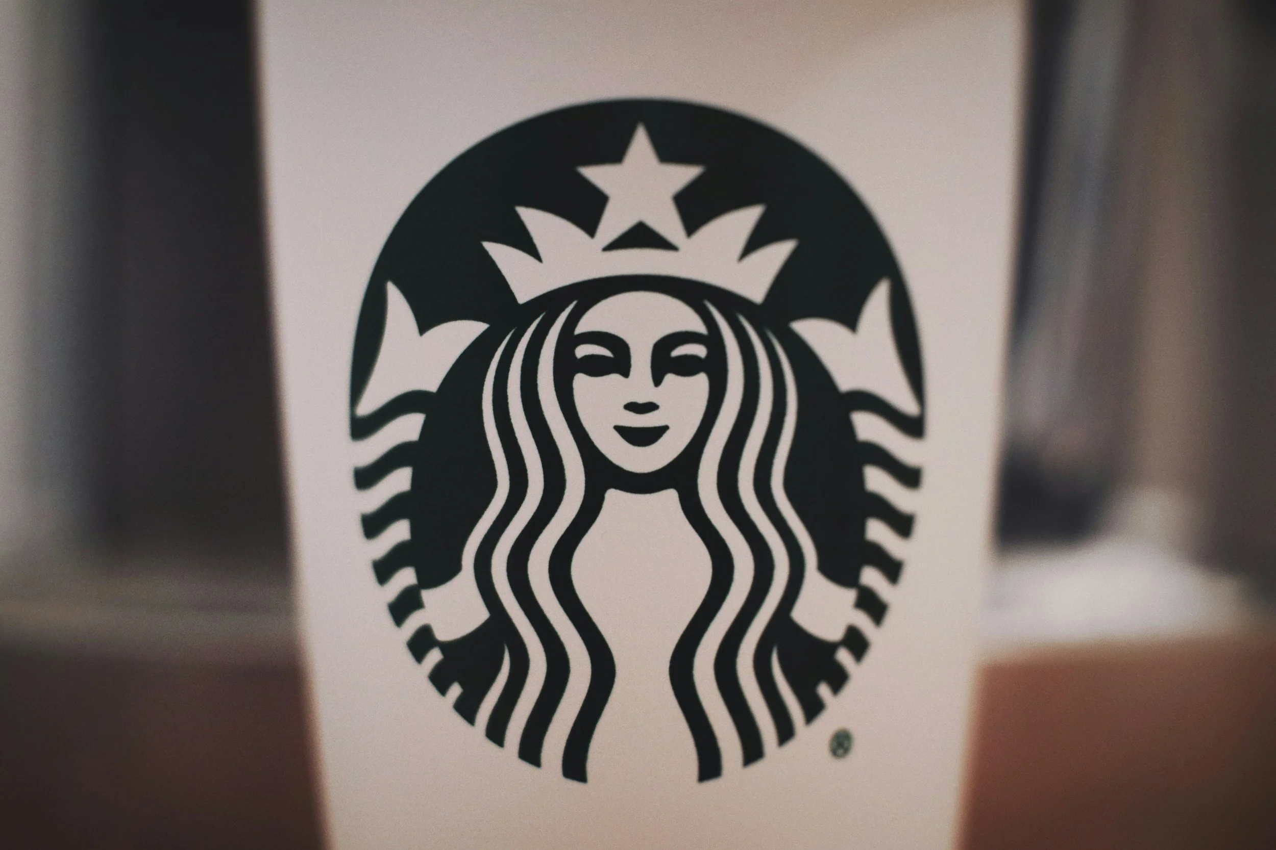 Close-up of a Starbucks logo with a mermaid in black on a white background.
