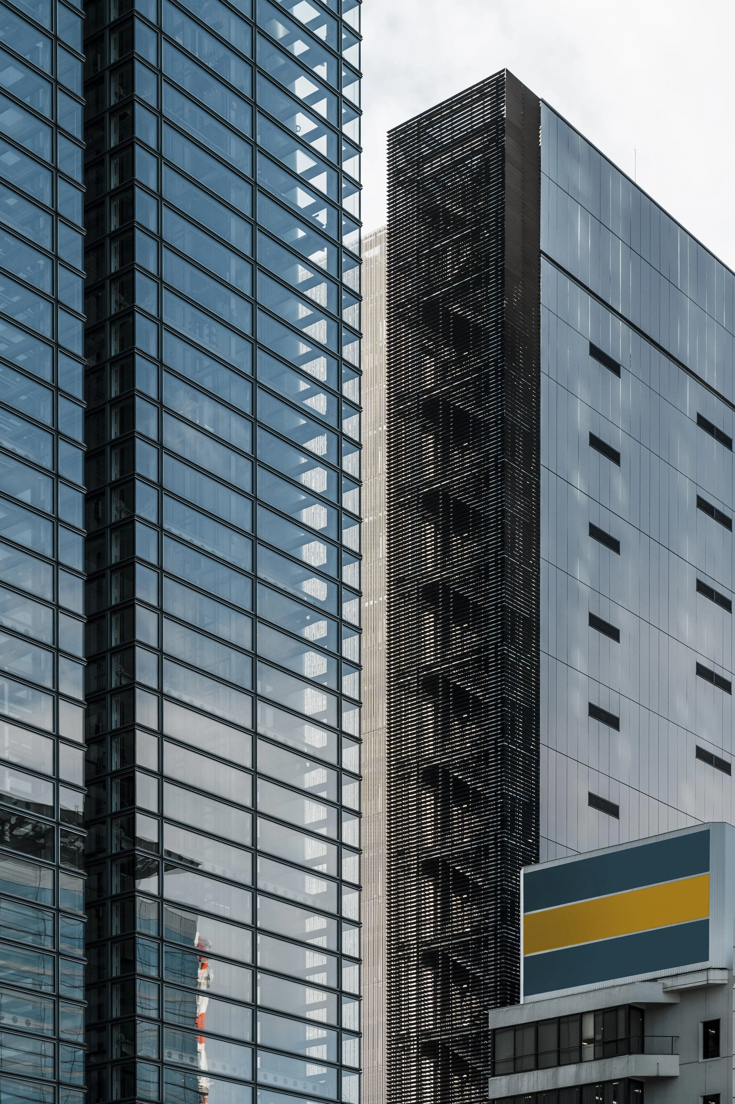 Modern high-rise buildings with glass and metal facades in an urban setting.