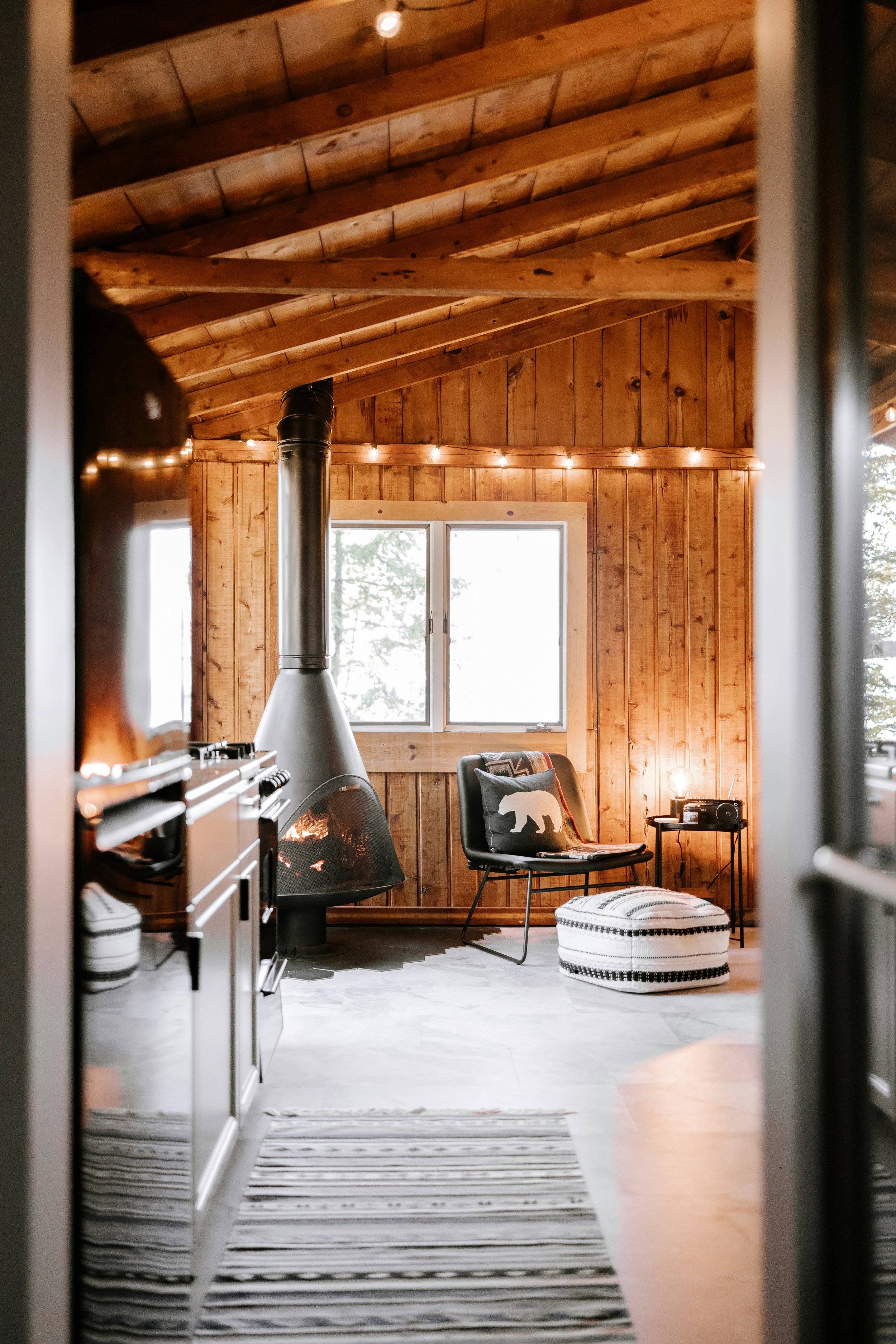 A warm wooden interior with soft lighting and a fireplace, representing home, emotional safety, and spaces that support rest, reflection, and a sense of belonging.