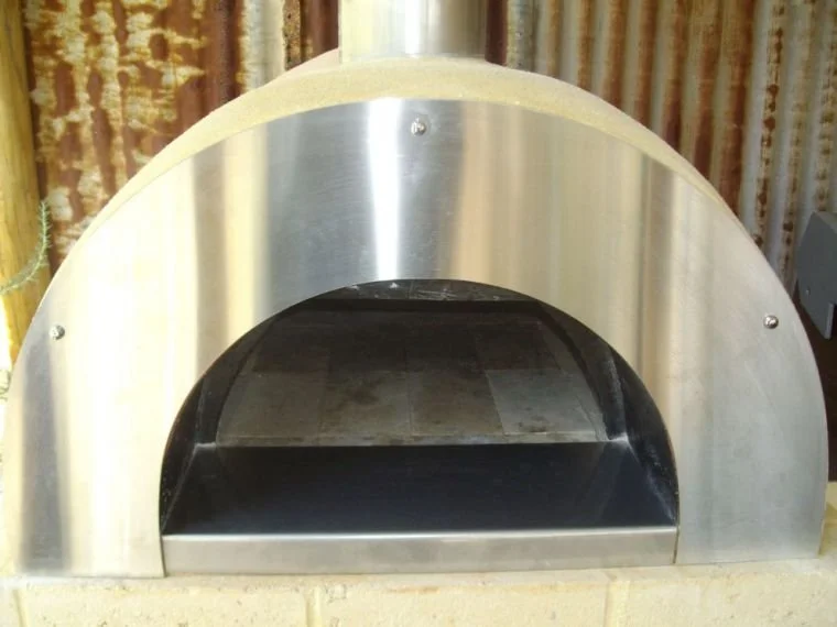 A stainless steel toaster oven with a rounded top and a black heating chamber inside.
