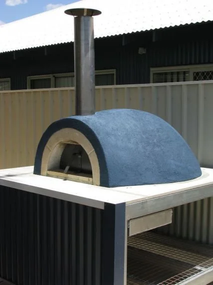 Outdoor pizza oven with a dome-shaped blue exterior and a chimney on top.