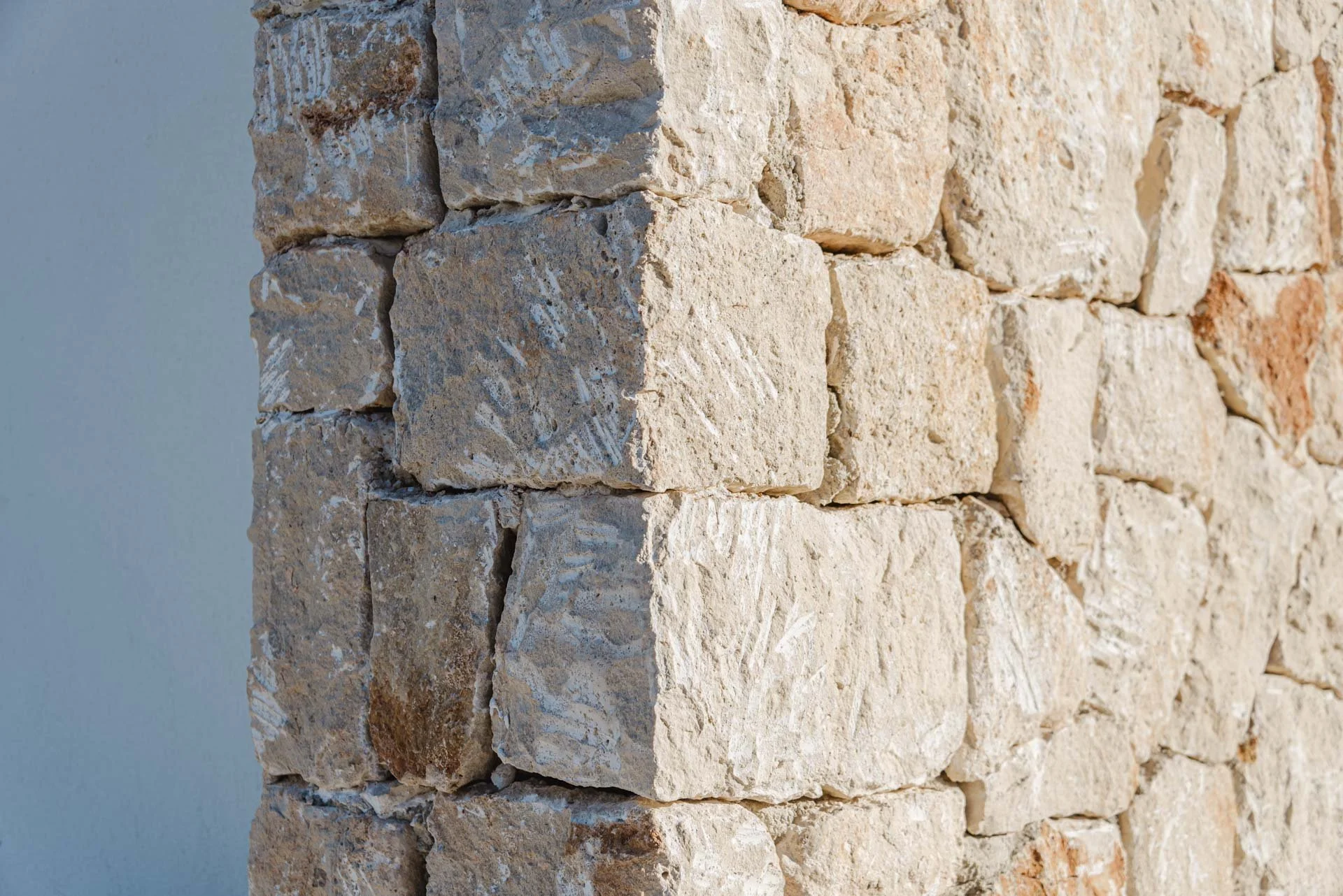 Close-up of a textured brick wall with beige and reddish-brown bricks.