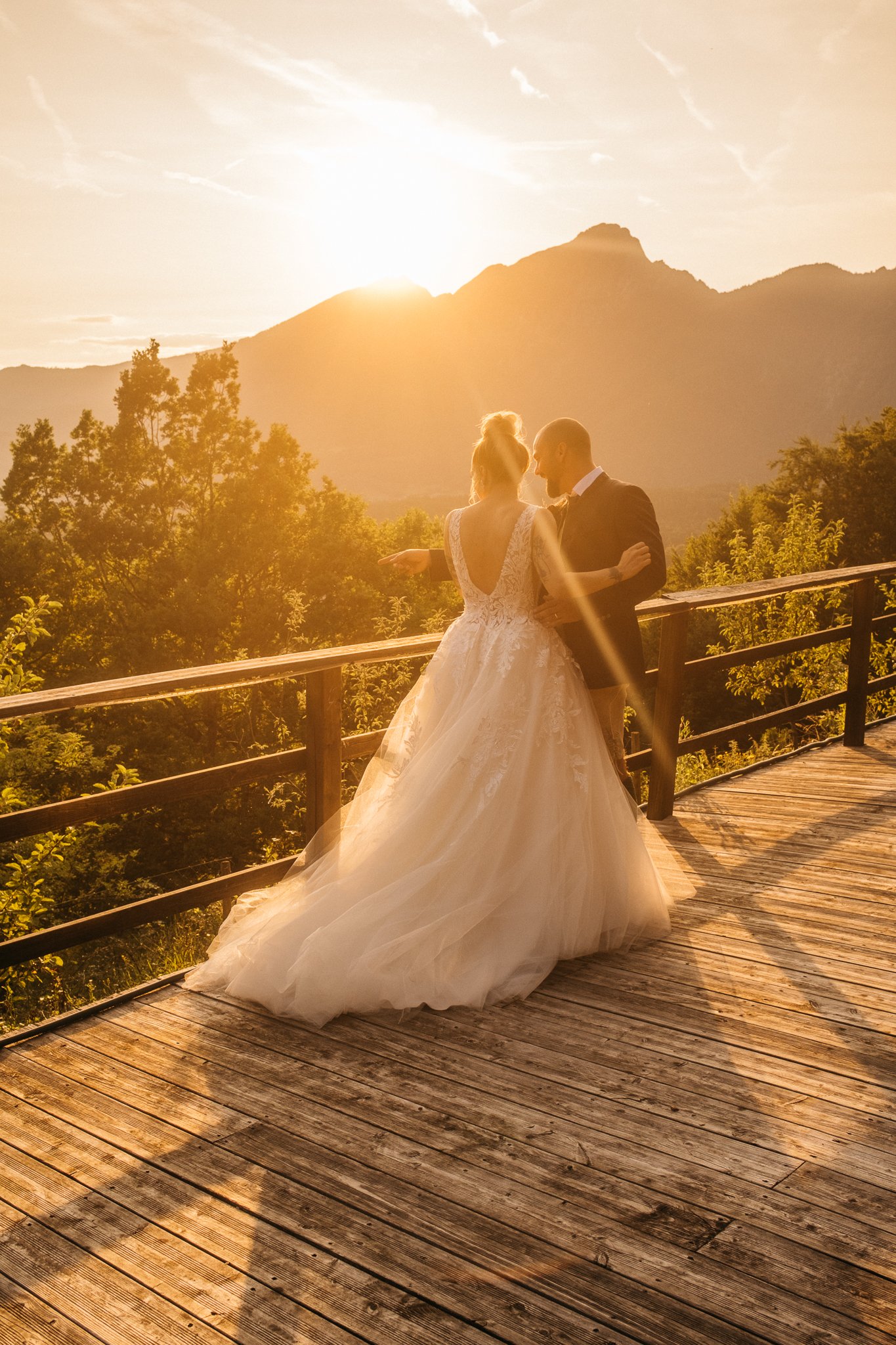 Frisch verheiratetes Ehepaar vor einer Bergkulisse bei Sonnenuntergang