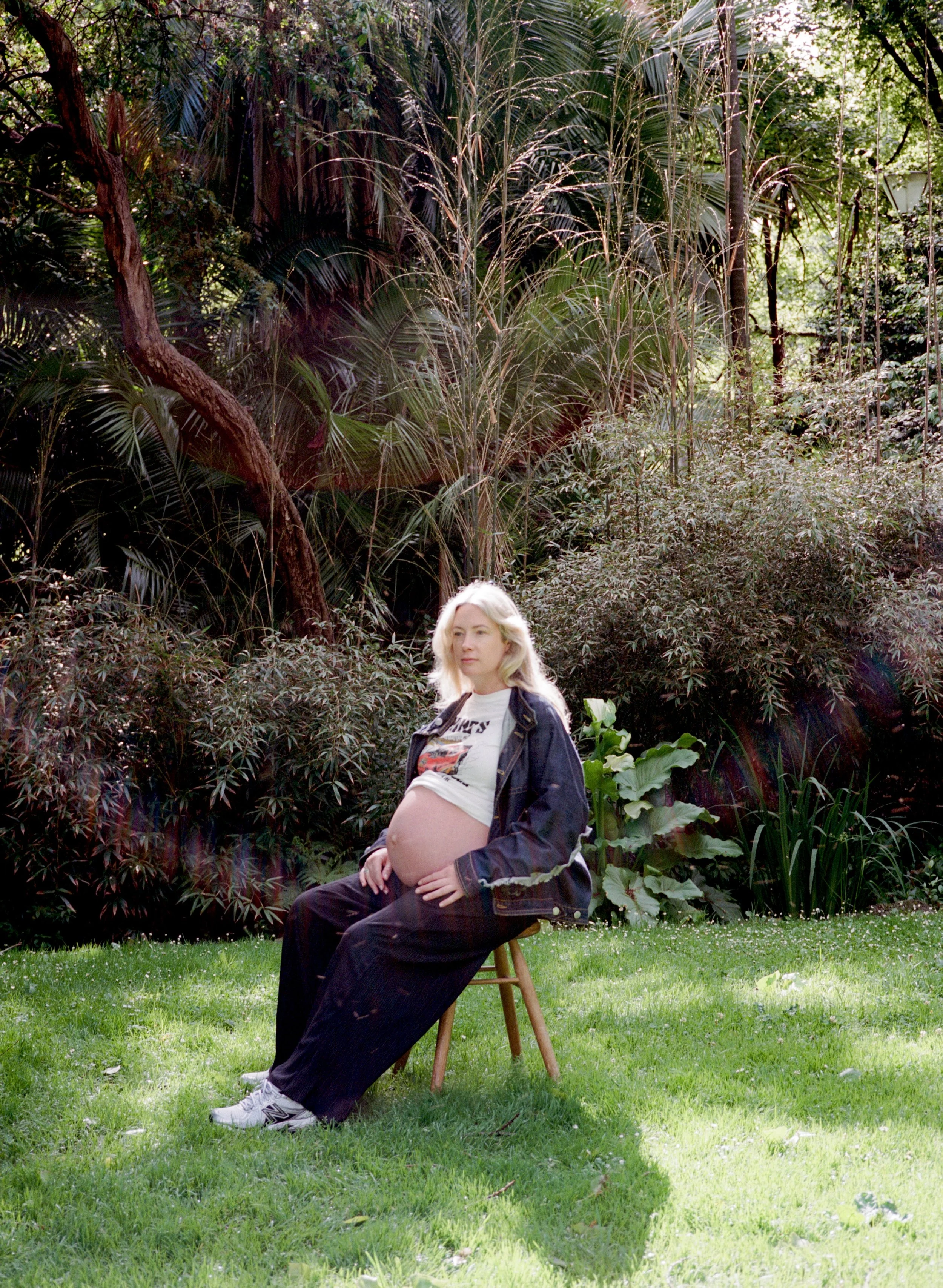Pregnant woman sitting in a sunlit garden, representing antenatal breastfeeding preparation