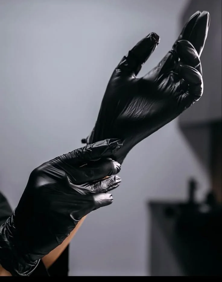 Tattoo artist Kissami is wearing gloves before a tattoo session.