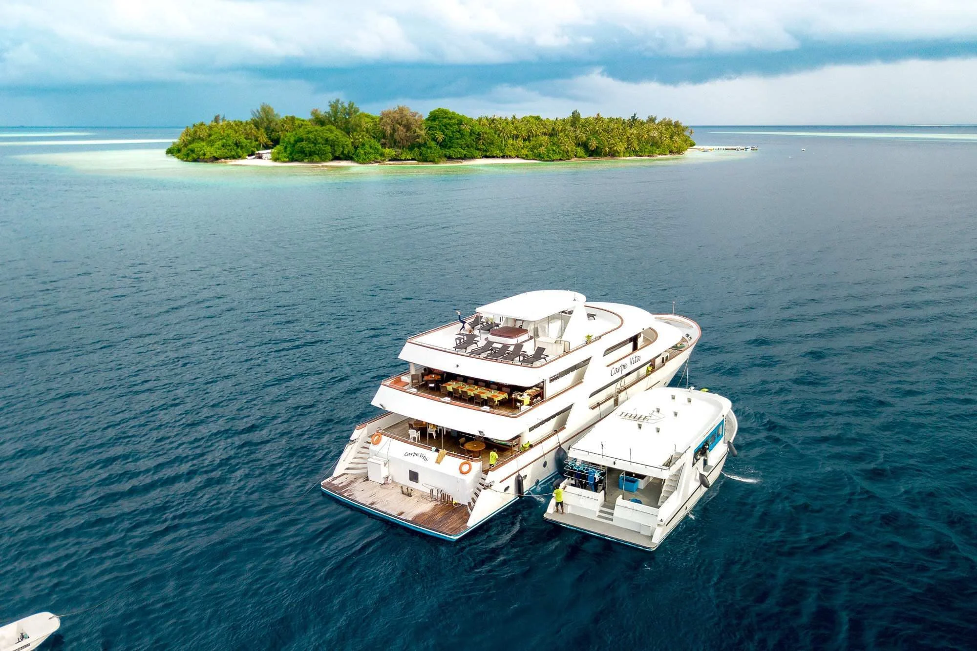 Carpe Vita liveaboard dive boat with its dhoni moored off an island in the Maldives