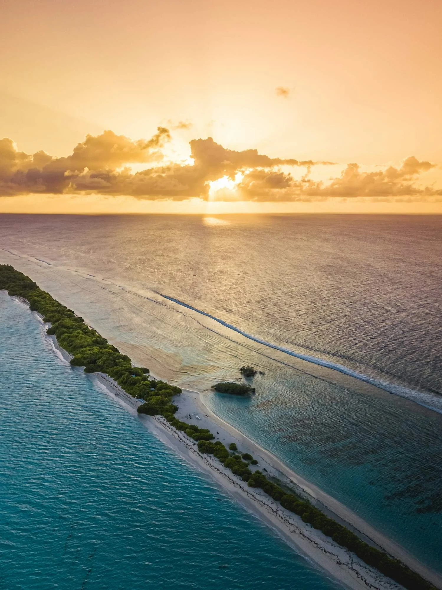 Dive boat at anchor off a Huvadhu Atoll island at sunset