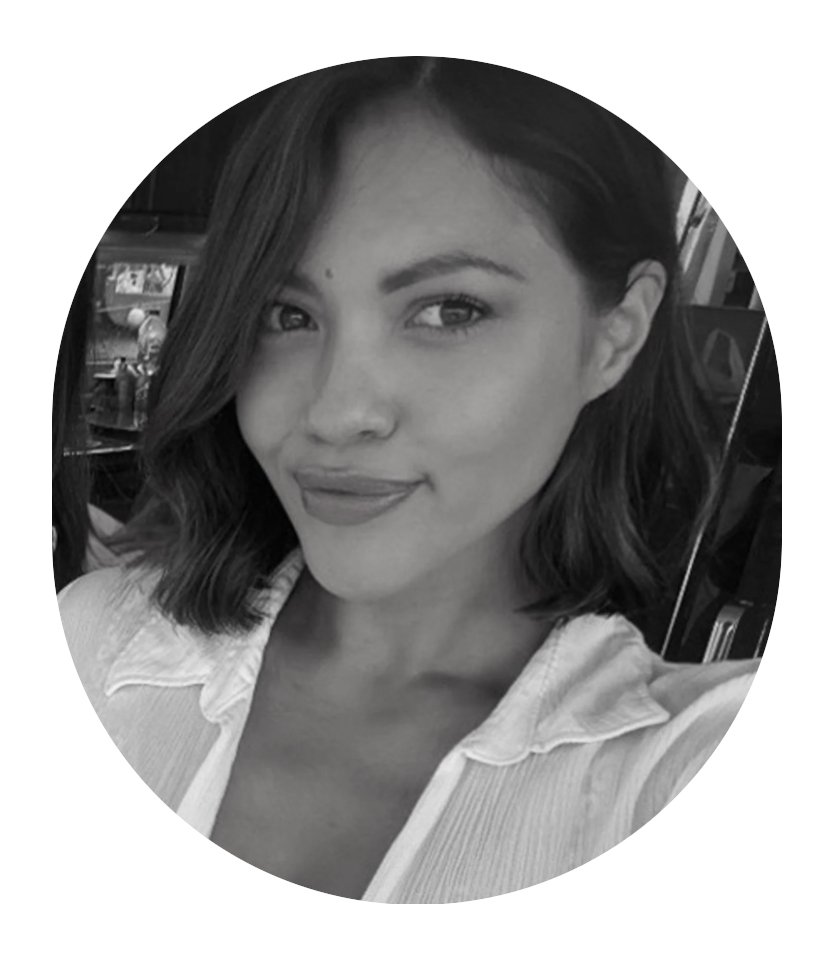 A young woman with short, wavy hair smiling at the camera, wearing a light-colored collared shirt, in a black-and-white photo.