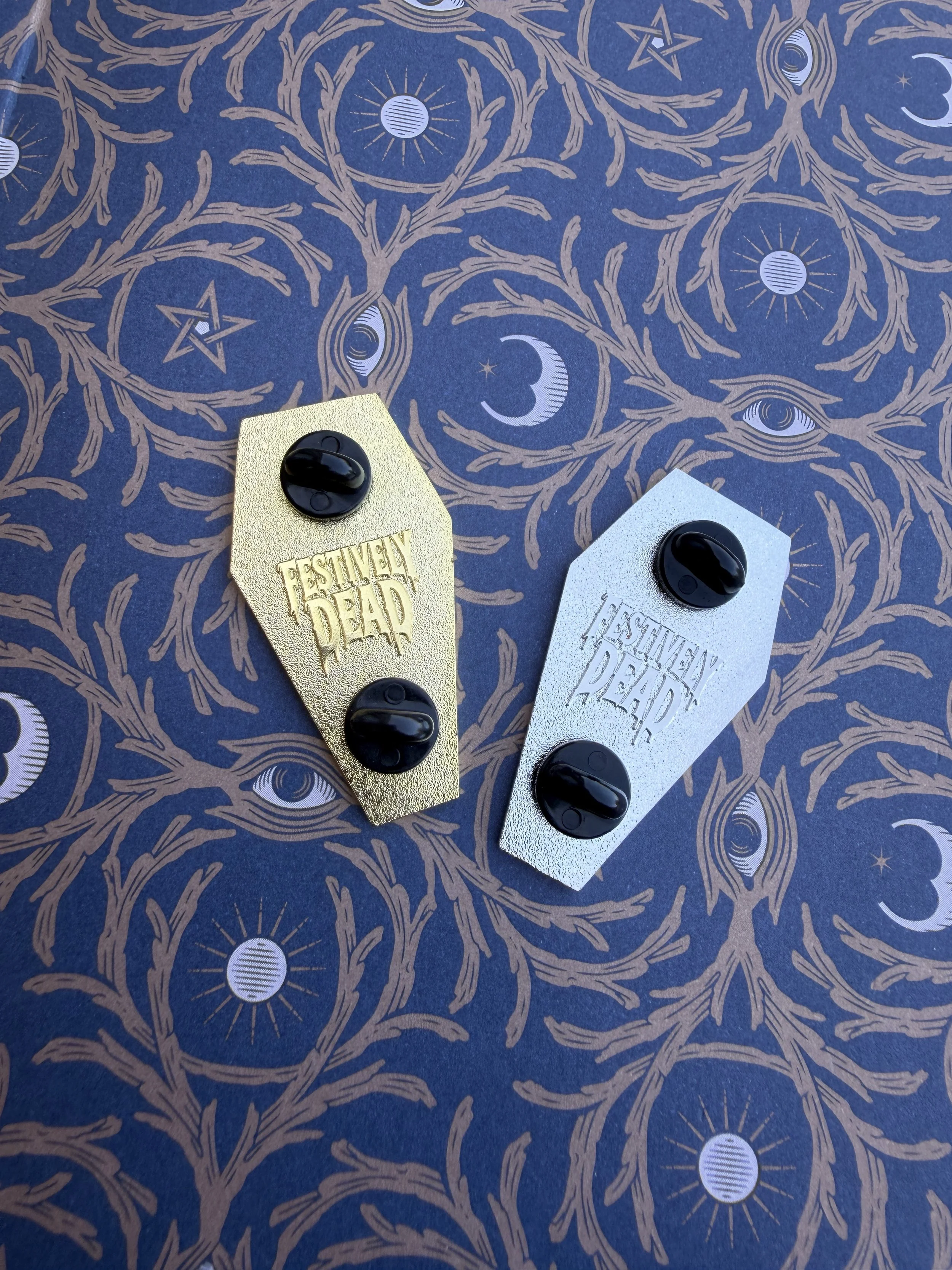 Gold coffin enamel pin with black enamel and dripping Festively Dead logo
