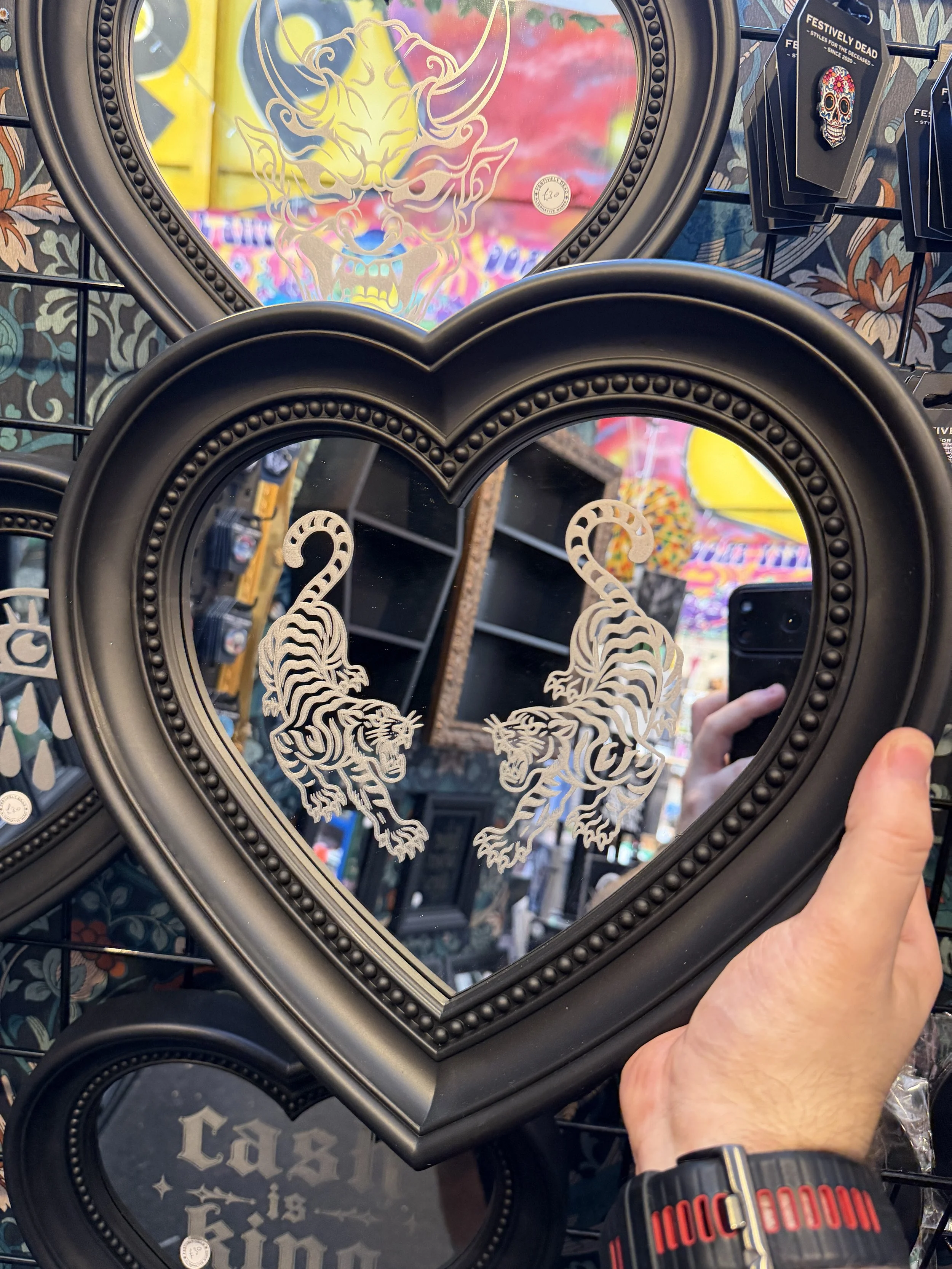 Black heart tiger mirror hanging on a patterned wall