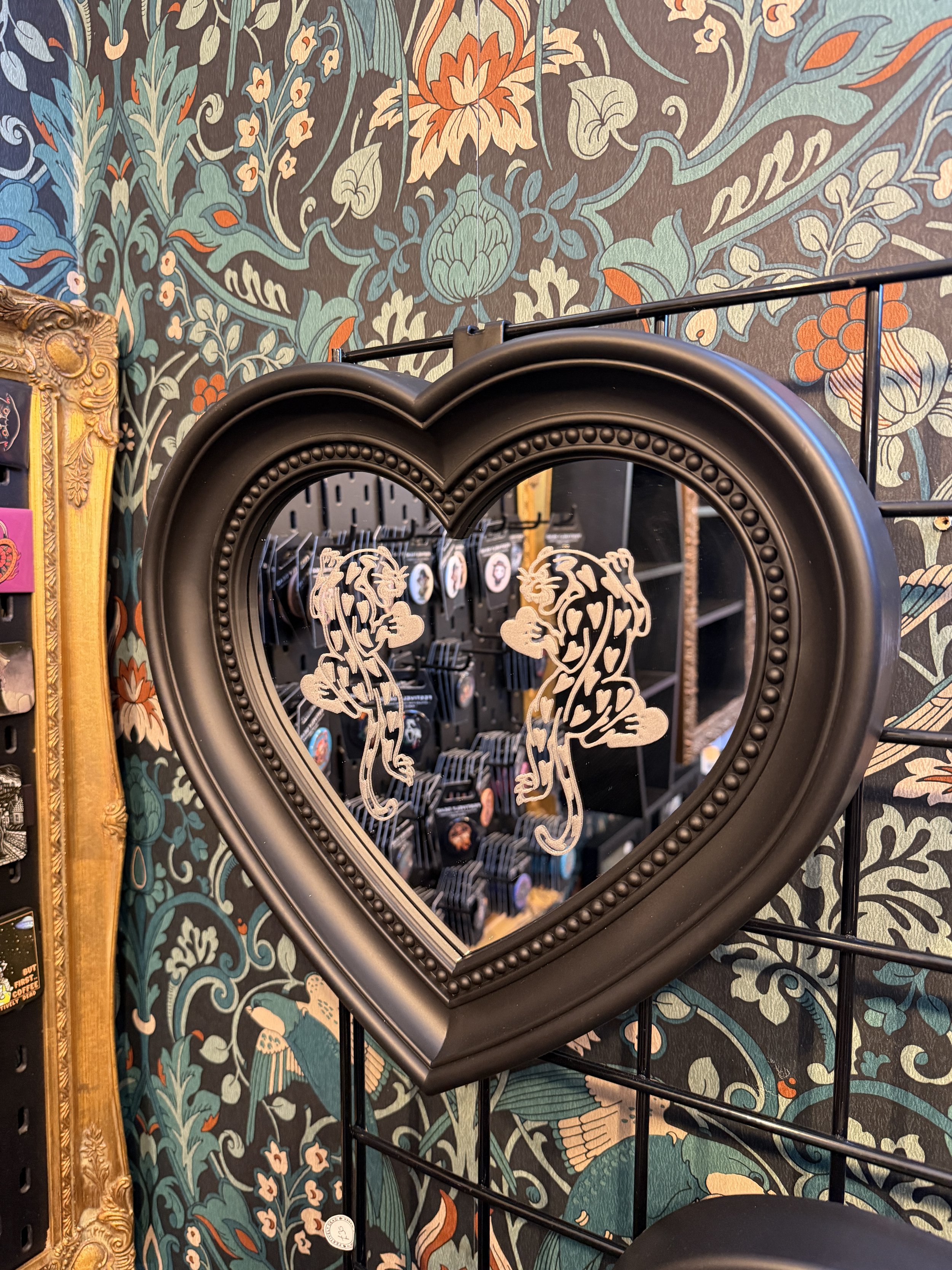 Heart panther mirror hanging in an alternative gift shop display