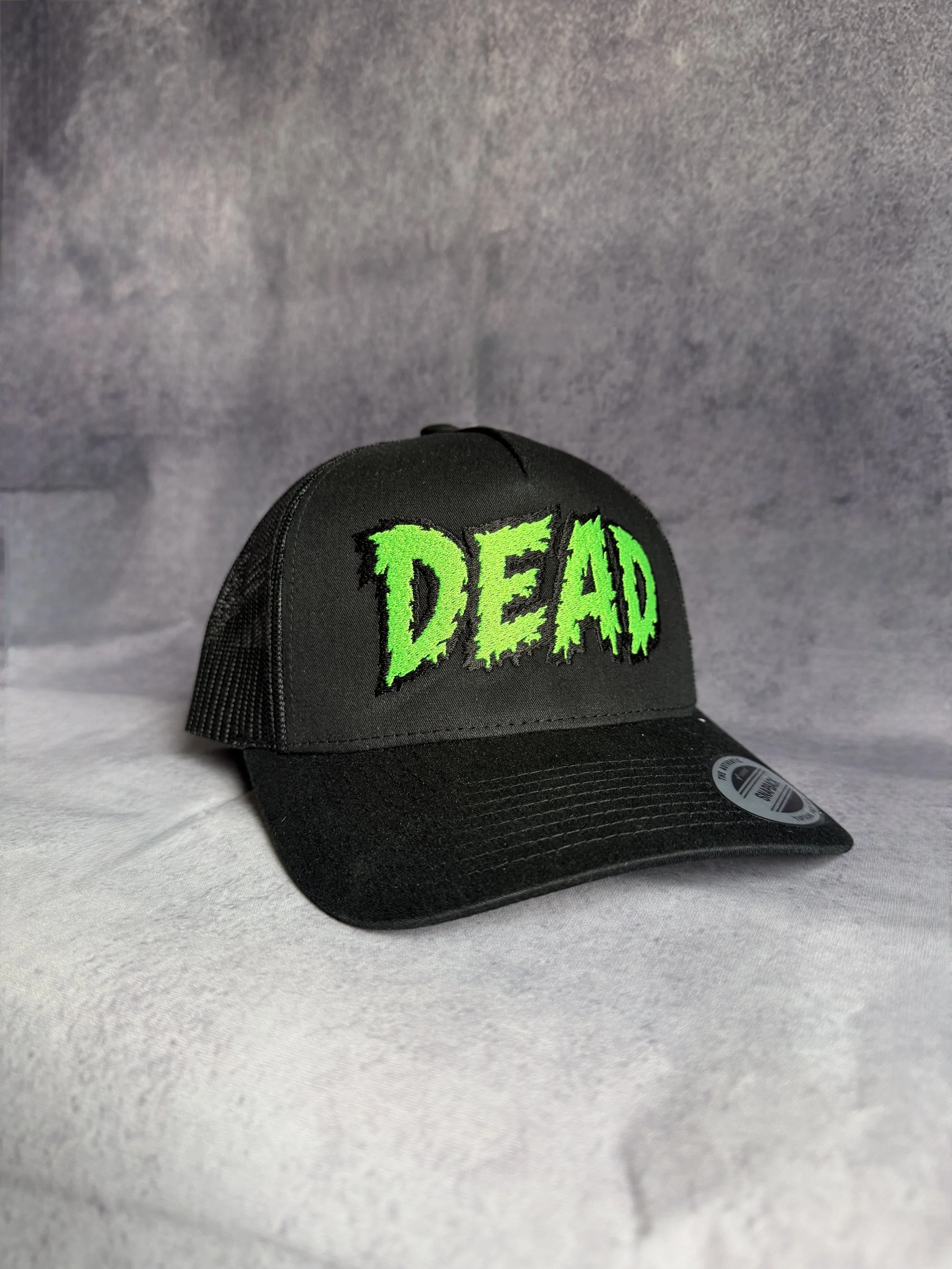 Black trucker cap with neon green DEAD horror font embroidery