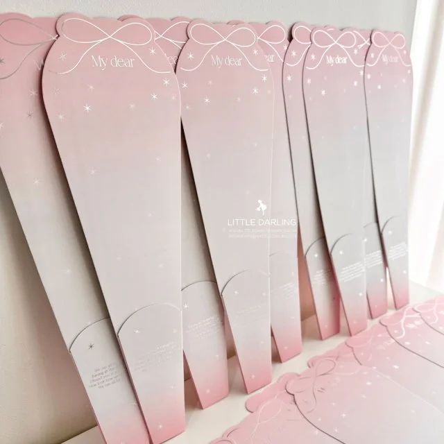 Multiple pink and white gift boxes with a bow design, labeled "My dear" at the top, arranged on a surface indoors.