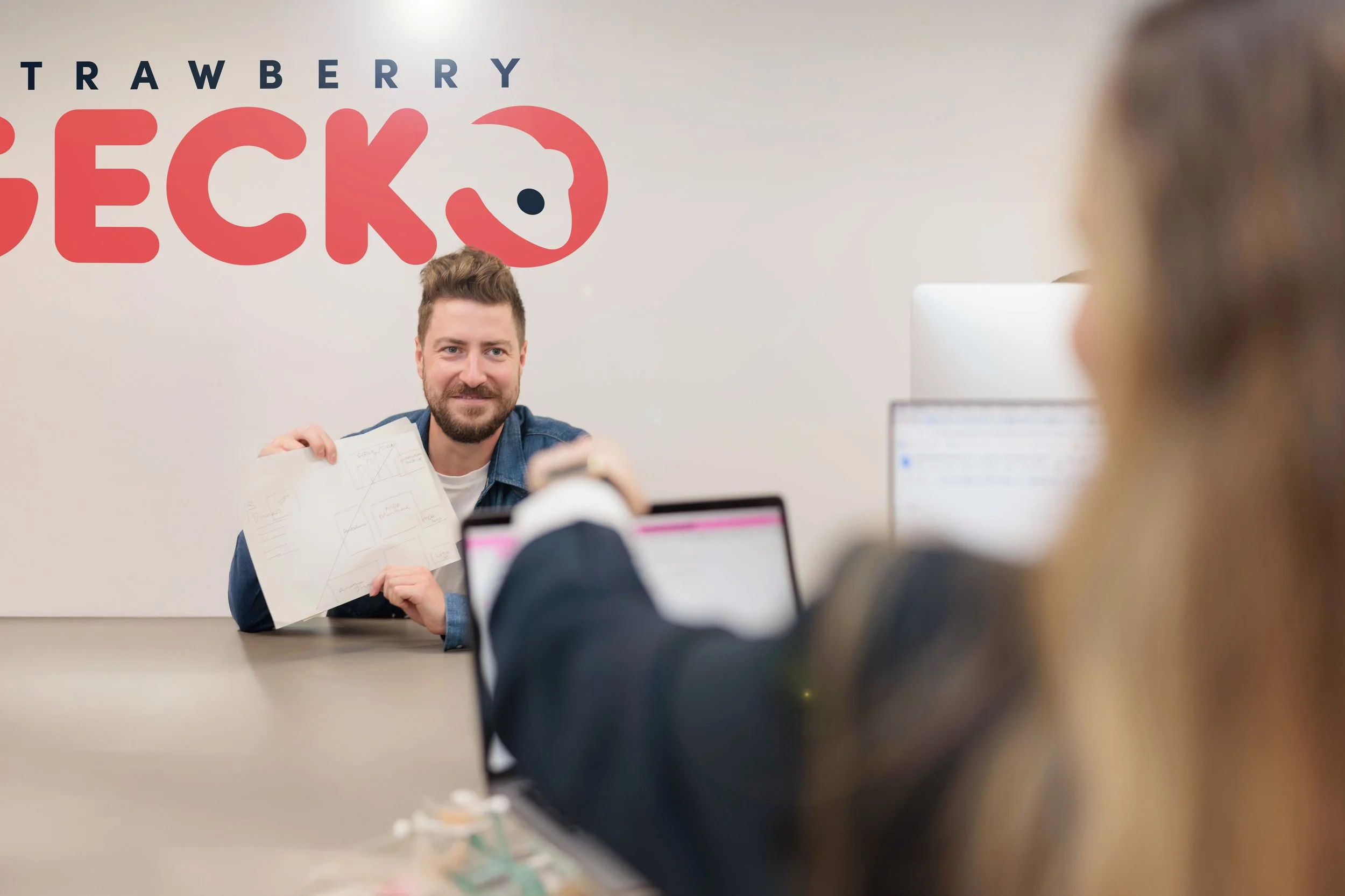 Man presenting a diagram during a meeting with a woman in an office.