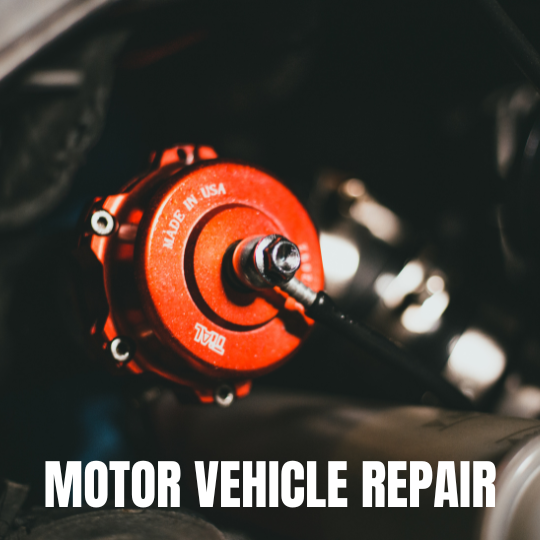 Close-up of a shiny red automotive part labeled "Made in USA" inside a car engine. The words "Motor Vehicle Repair" are overlaid in bold white text.