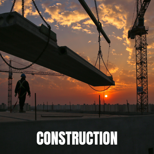 A construction worker in silhouette watches a crane lifting a beam at sunset. The sky is orange and dramatic, conveying a sense of hard work and progress. Text reads "Construction."
