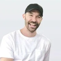 Image of Ross Langley, with a beard and white t shirt, wearing a cap