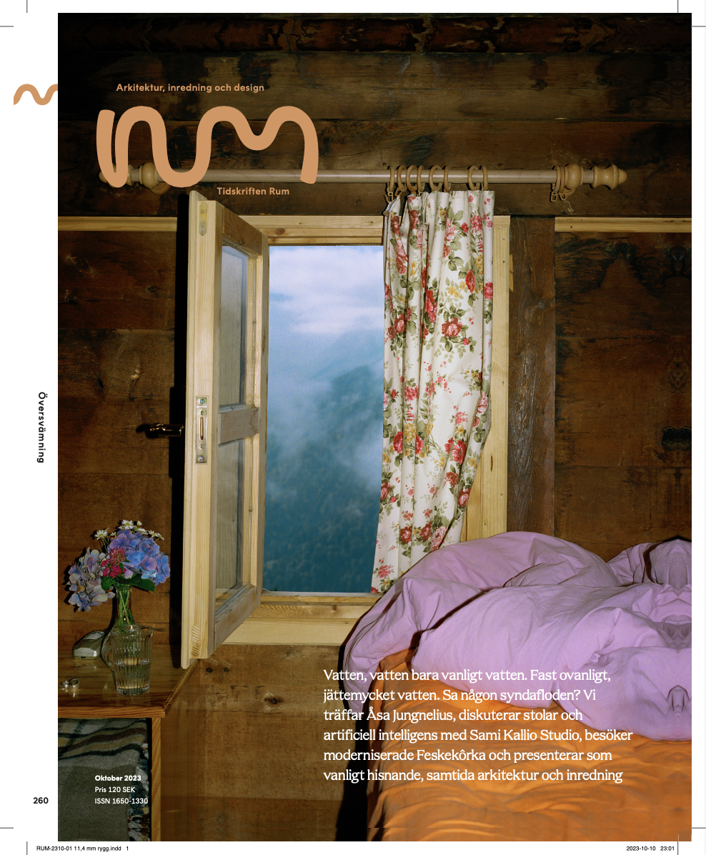 Una habitación en una cabaña de madera con una cama con sábanas rosas y una ventana con cortinas florales, abierta con una vista de montañas y cielo