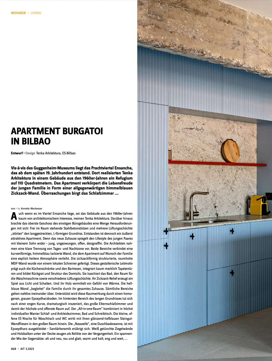 Artículo de revista sobre un apartamento en Bilbao, con imagen de una pared azul con paneles y detalles de diseño interior.