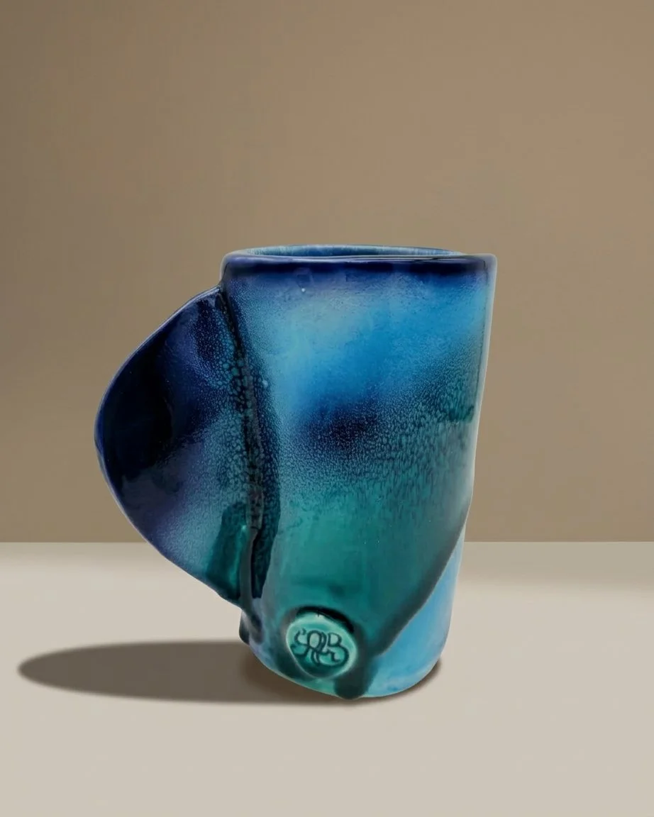 Vase en céramique bleu avec un motif de bulles et un logo en bas