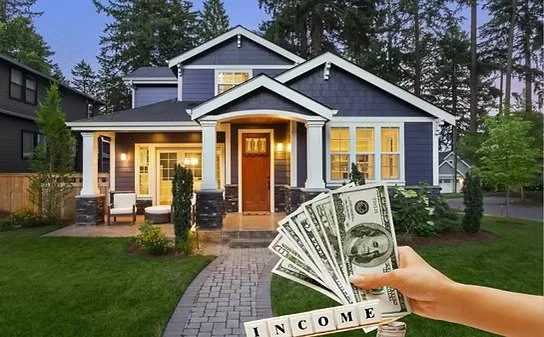 Hand holding dollar bills spelling out 'INCOME' in front of a large blue suburban house with a manicured lawn.