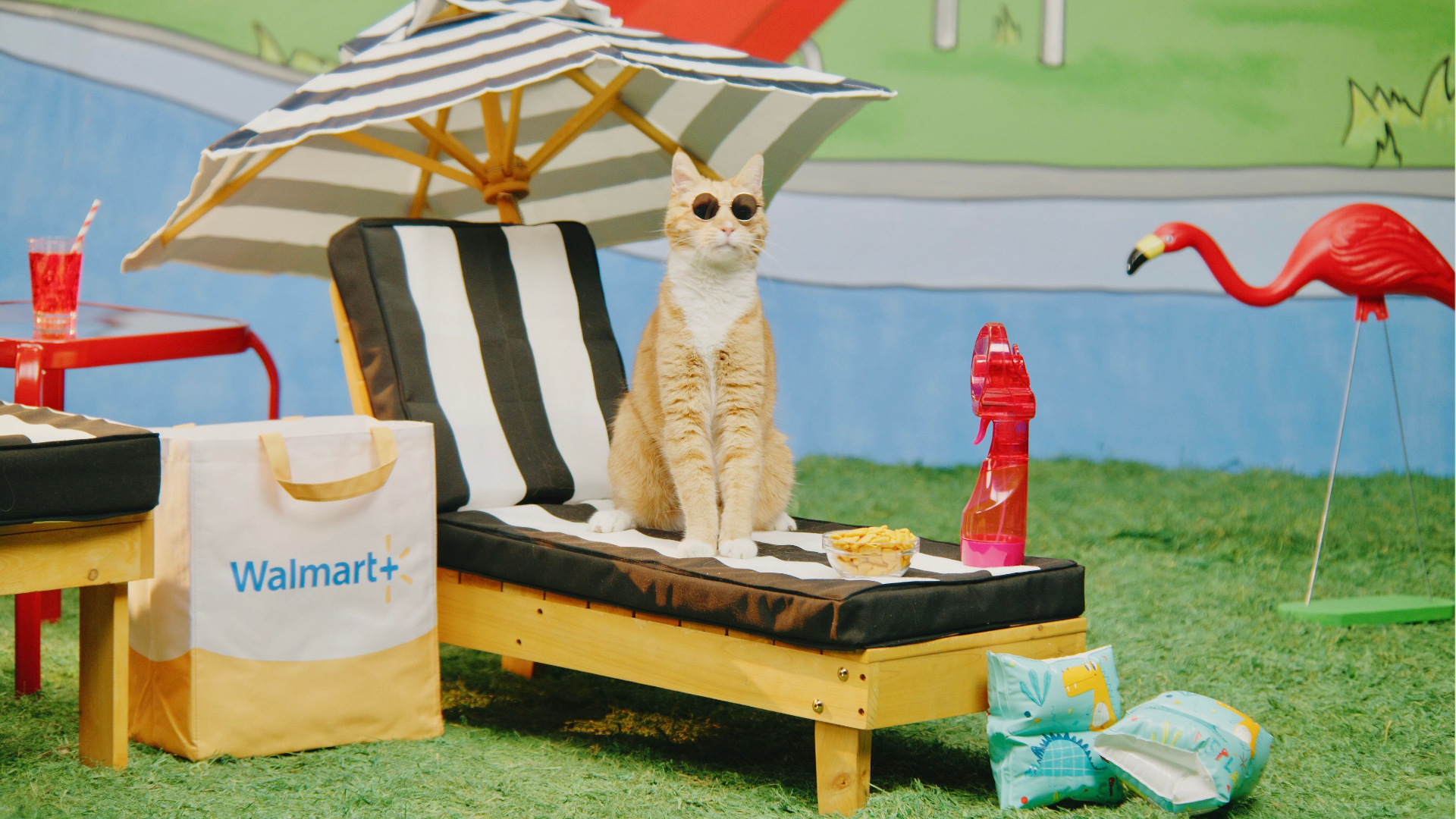 Campaign image produced by The Aux Co featuring a stylized beach scene with a cat in sunglasses, Walmart branded props, and playful summertime set design.