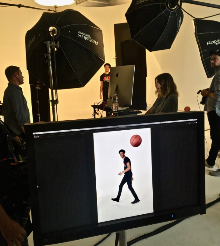 Behind the scenes of a commercial studio shoot produced by The Aux Co featuring professional lighting, crew on set, and a basketball themed visual on the monitor.