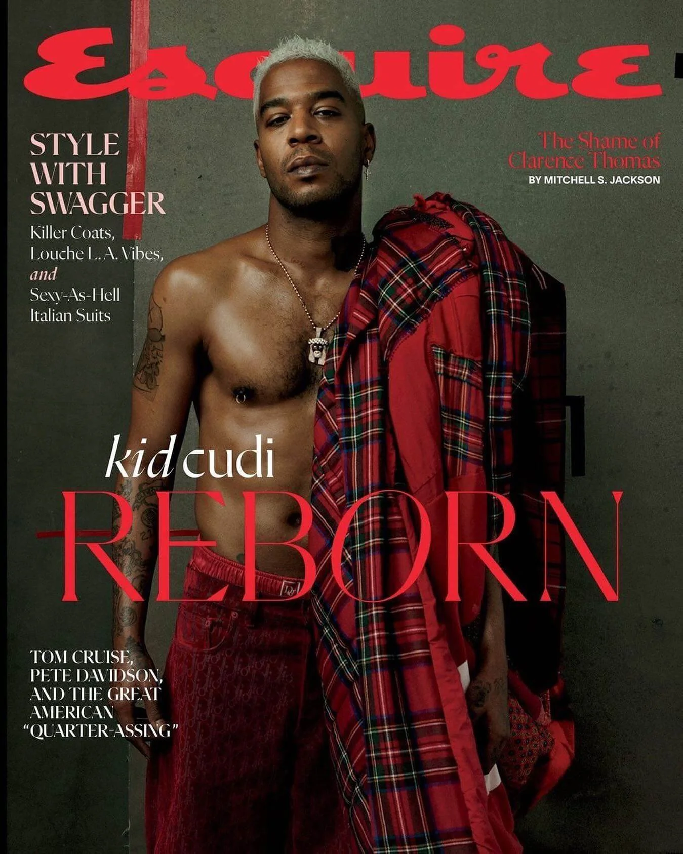 Cover of a magazine featuring a shirtless male model with blond hair holding a red plaid garment, with gray wall background and red and white text