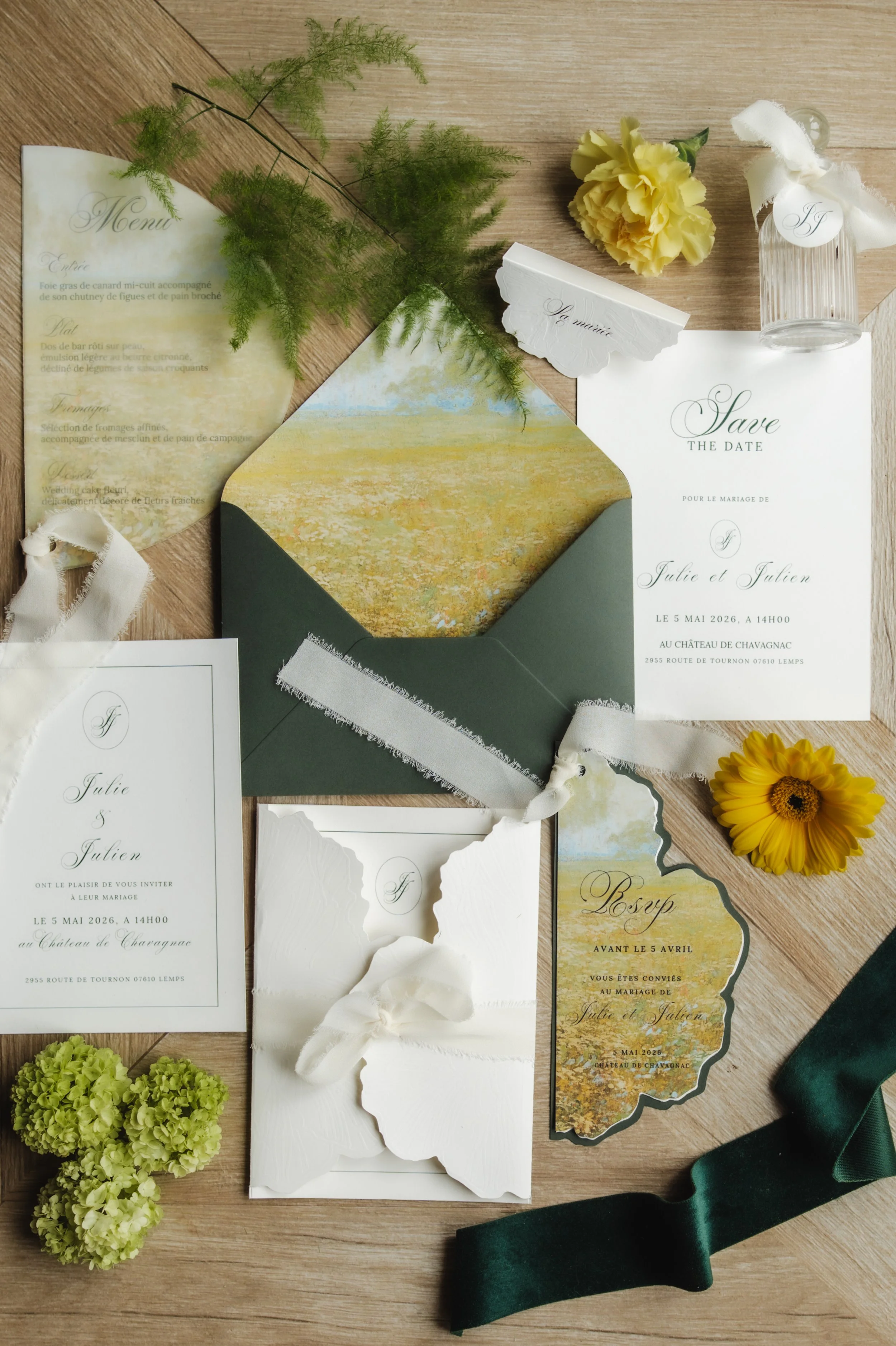 Invitation de mariage, menu, fleures, bloc-notes, ruban en satin vert, accessoires de décoration sur une table en bois.